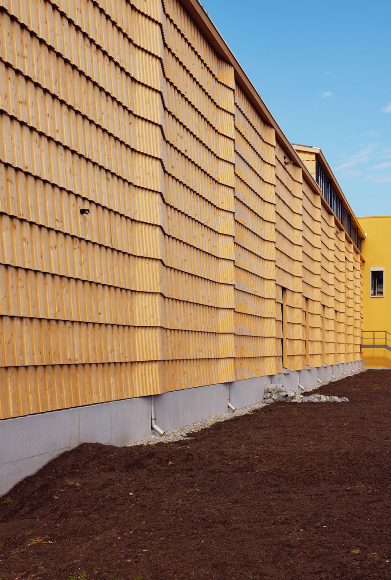 Die Hülle umschliesst auf der Nordseite die aussenliegende vertikale Entwässerung mit sanften Aufwölbungen.