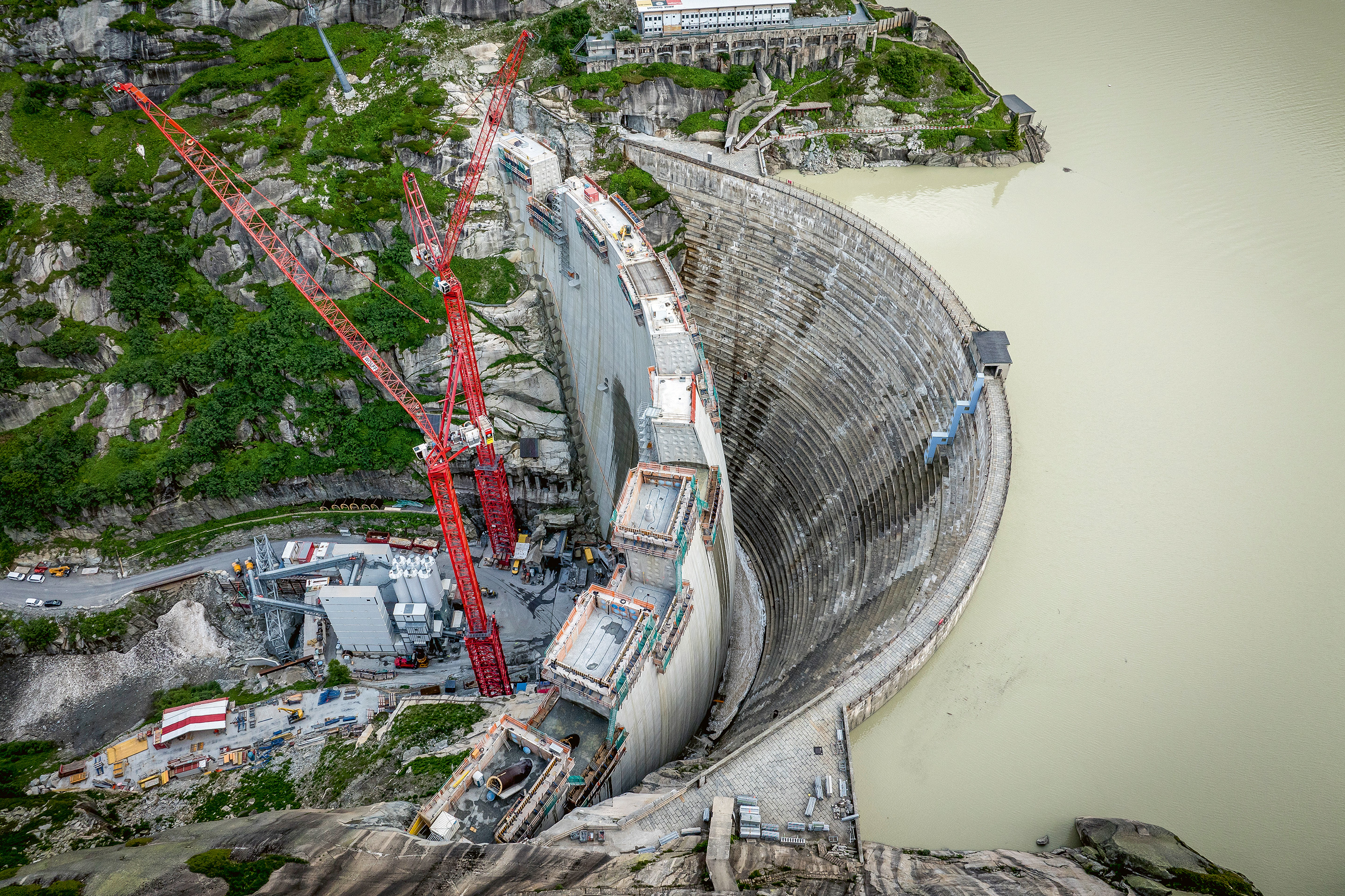 Les derniers plots de béton sont coulés. Le nouveau mur a été construit à l’abri du barrage existant. Pendant la durée des travaux, le Grimselsee a pu rester en eau et a donc continué à alimenter la production d’électricité.
