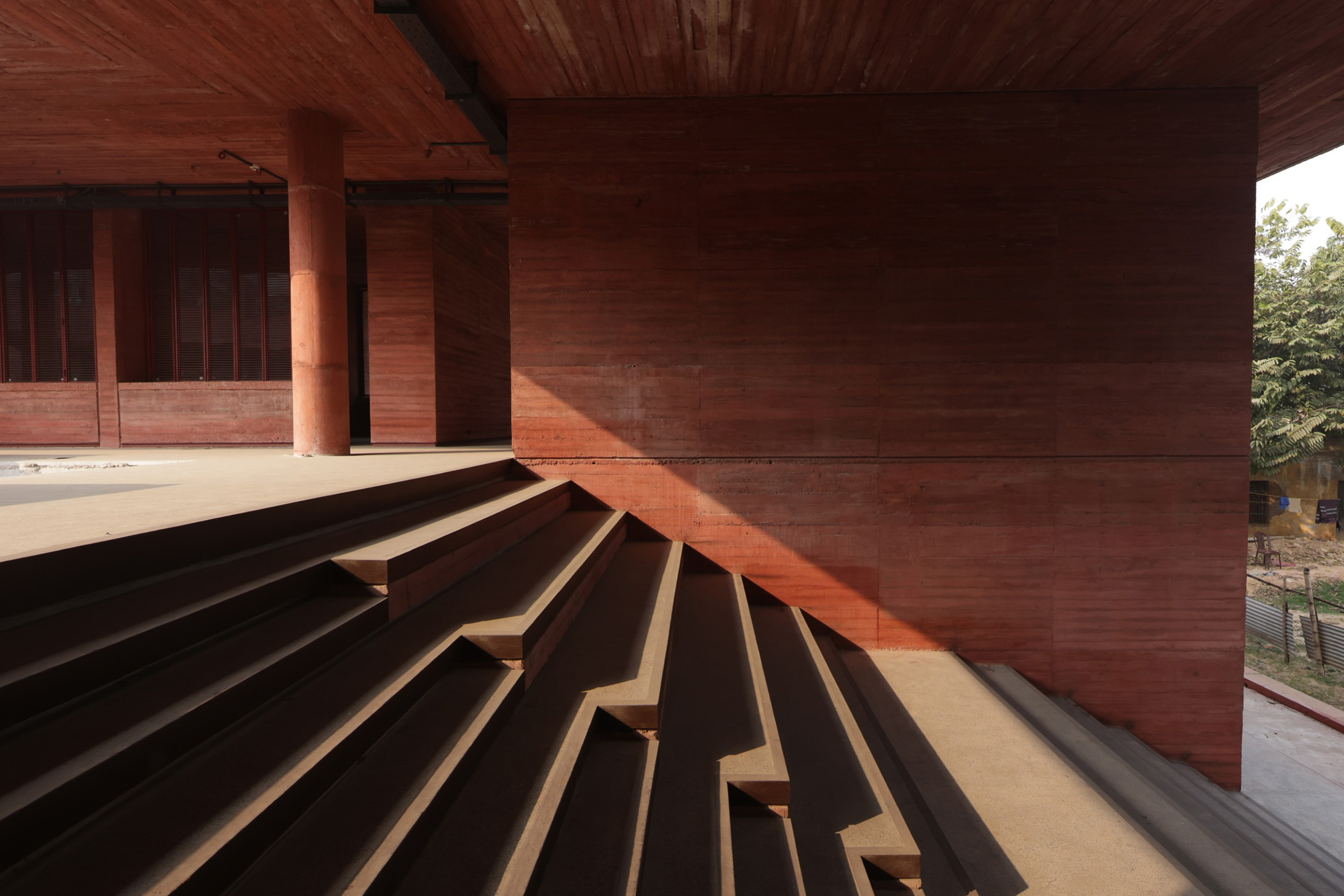 Sièges en amphithéâtre intégrés dans la zone de passage de l'entrée.