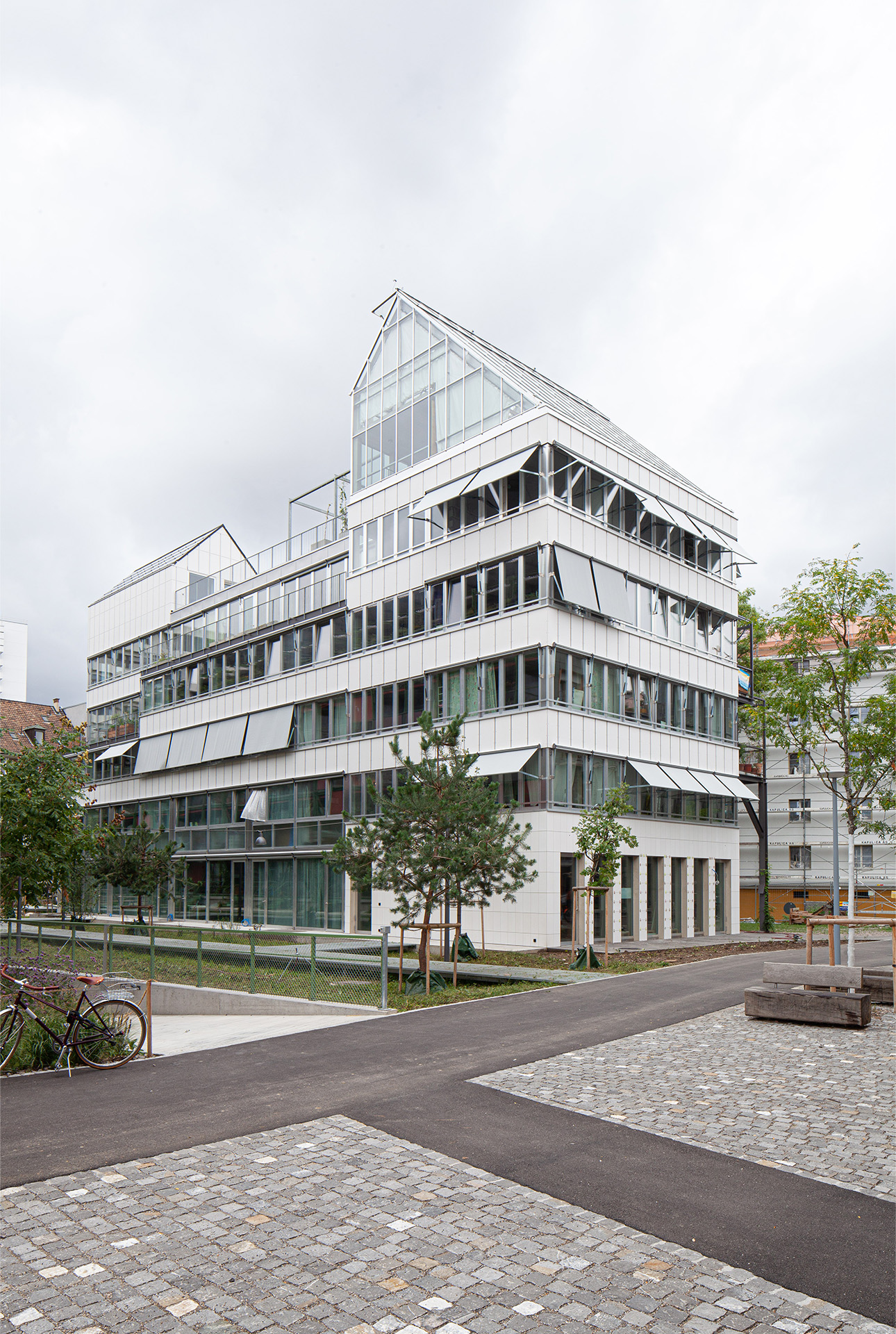 Fensterbänder und weisse Faserzementplatten zieren die Nordfassade der Lyse-Lotte und schaffen einen reflektierend leichten Gesamteindruck.