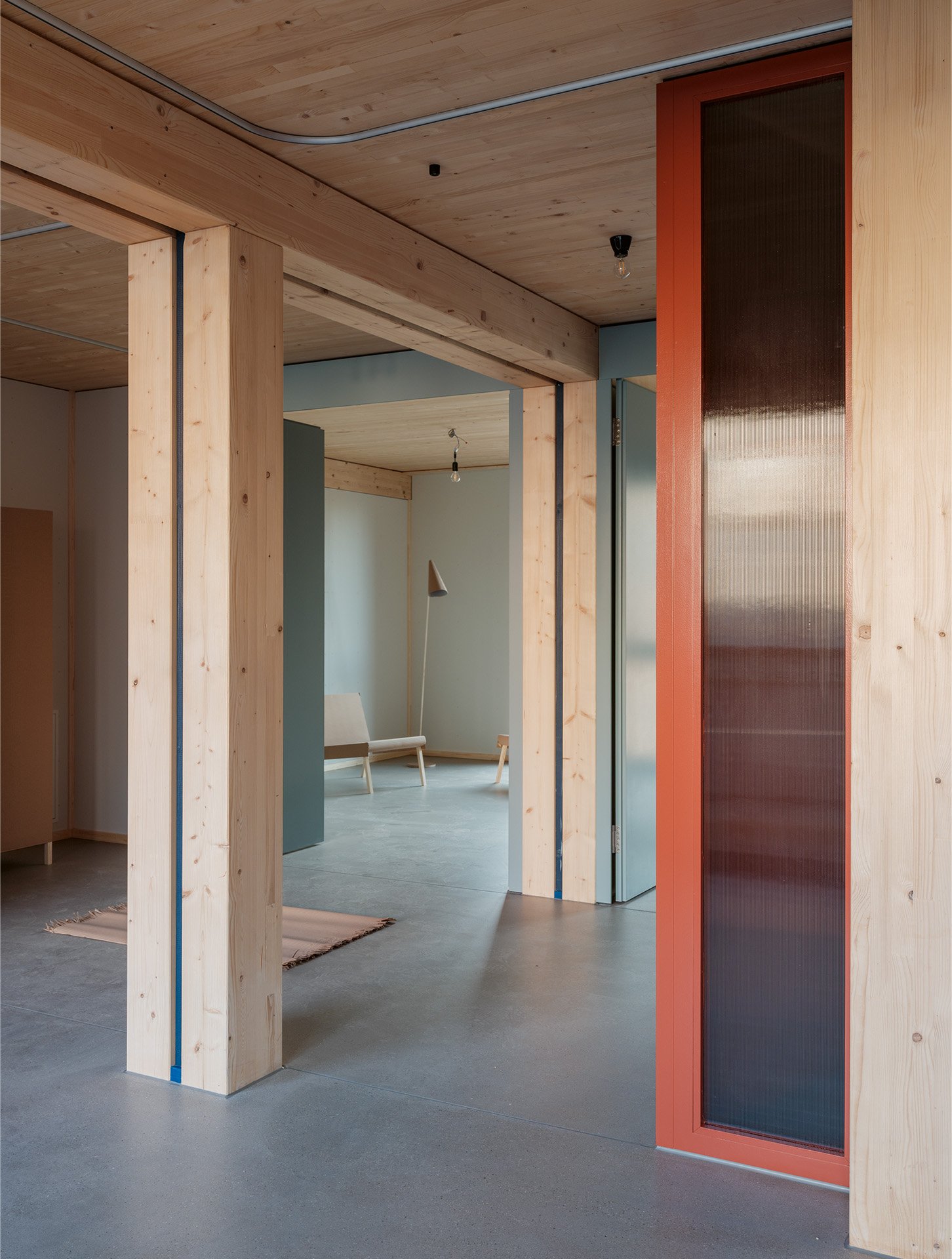 Blick von der Küche zu den Zimmern: Die Rasterung der Holzkonstruktion prägt die Innenräume.