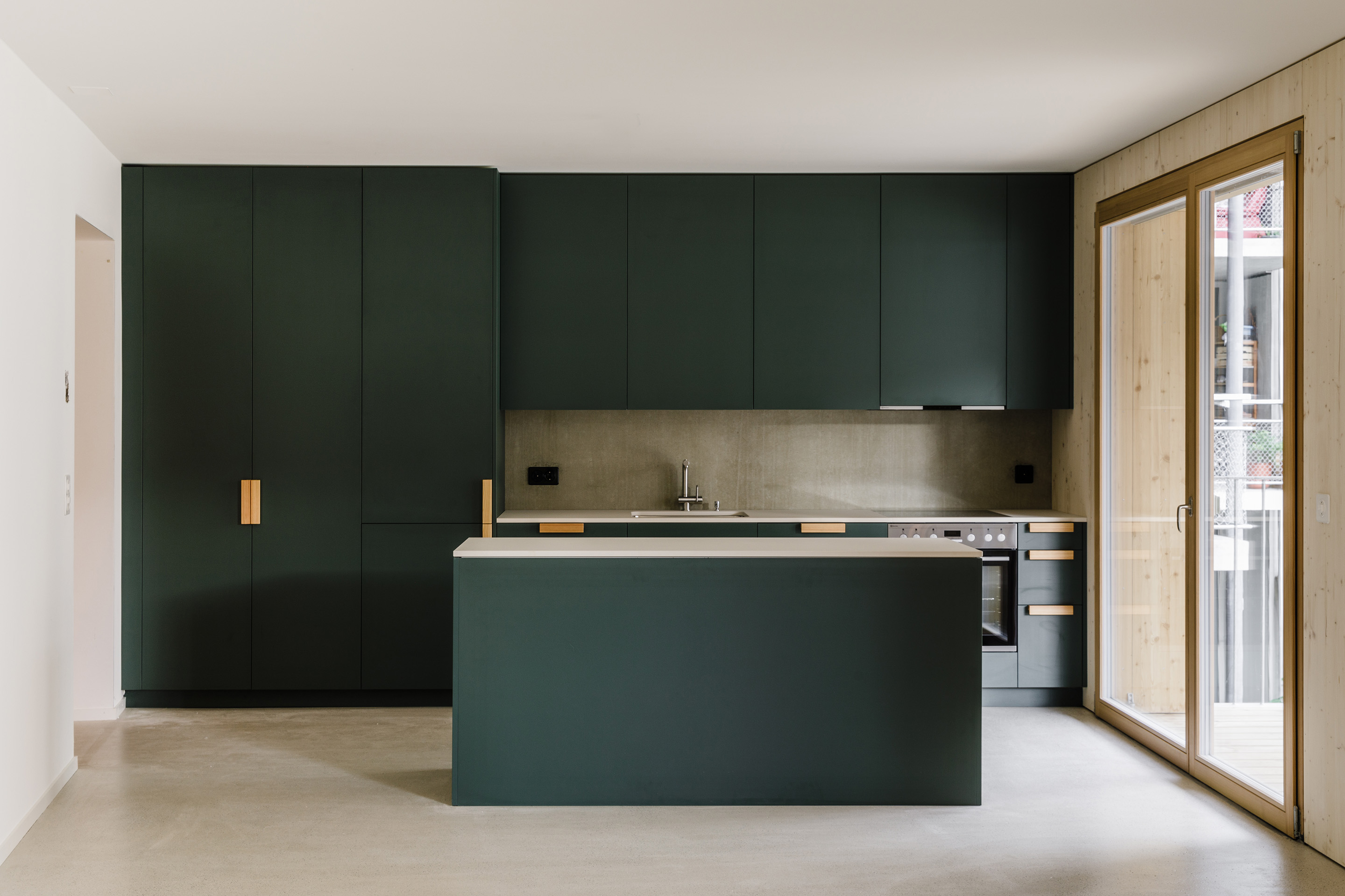 Die Küchenfronten konnten die Bewohnenden selbst mitaussuchen, aus einem Farbkanon von blau bis grün.