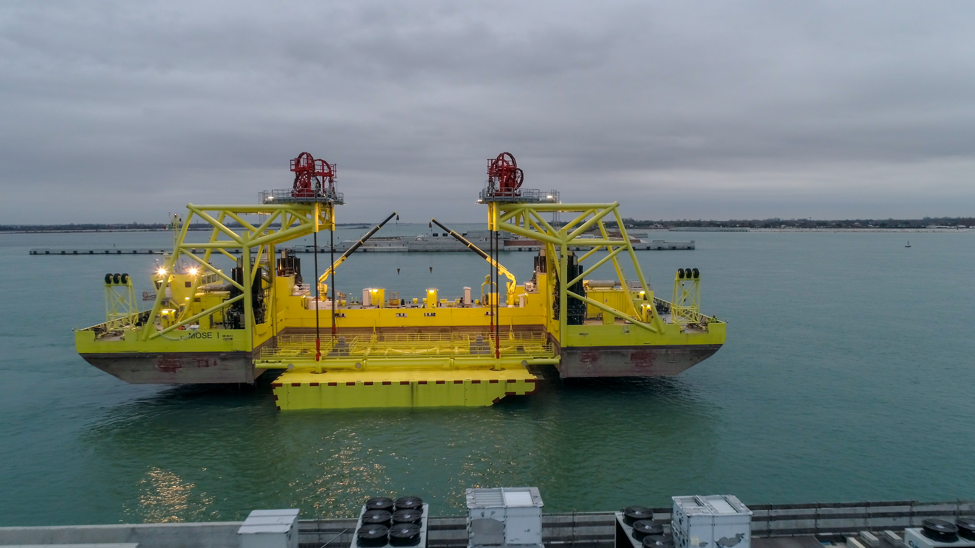 Le «Jack-up», destiné aux opérations de mise en place et de maintenance pendant l’exploitation de la barrière prévoyant le remplacement périodique de toutes les vannes, est un ponton spécial composé de deux demi-coques reliées entre elles, capable de s’allonger ou de se raccourcir en fonction des vannes à transporter et à accrocher.