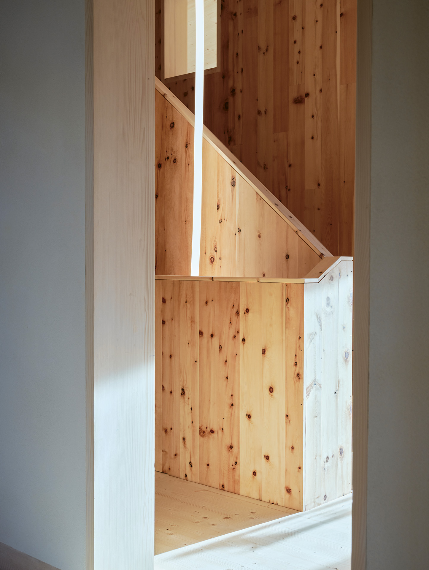 Die Heizung ist in den mit Lehm verputzten  Treppenkern integriert, der im Innern mit duftendem Arvenholz verkleidet ist.