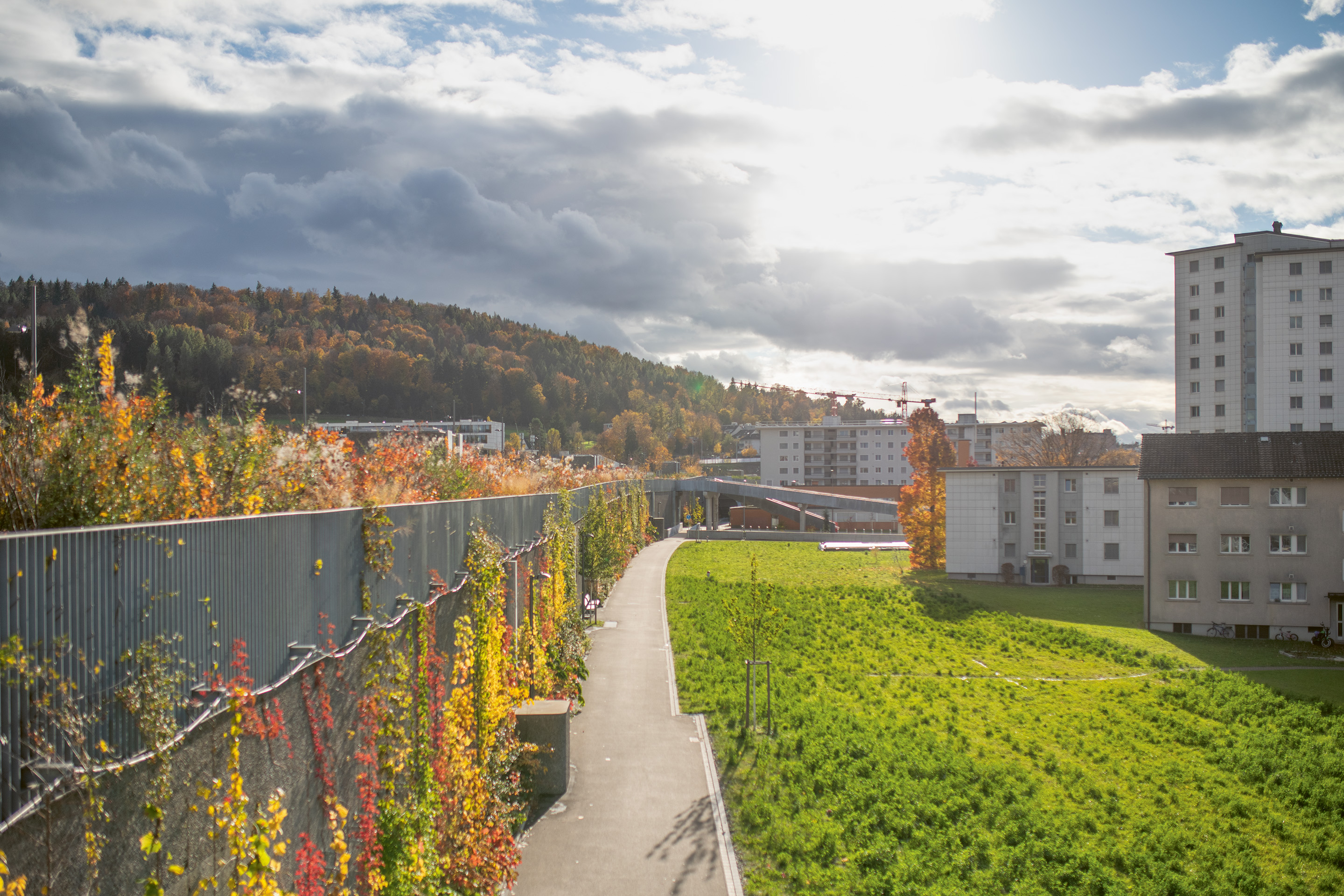 Da ein Damm über die gesamte Länge der Einhausung technisch nicht umsetzbar war, führen Treppen und Rampen auf den 8 Meter hohen Park.