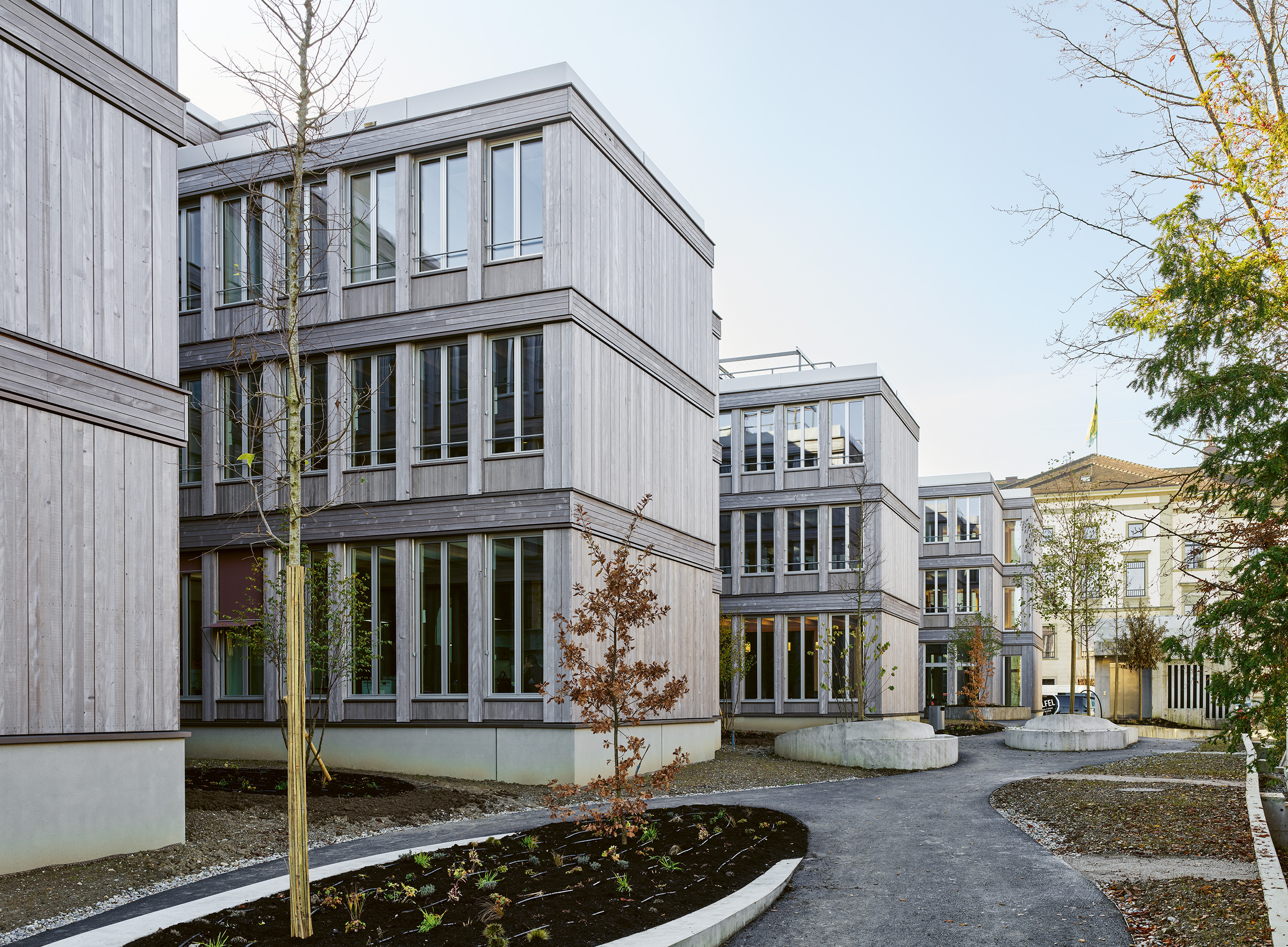 Die Struktur der Fassade verbindet sich mit dem klassizistischen Regierungsgebäude und der frühere Parkplatz ist jetzt ein hofartiger kleiner Park.