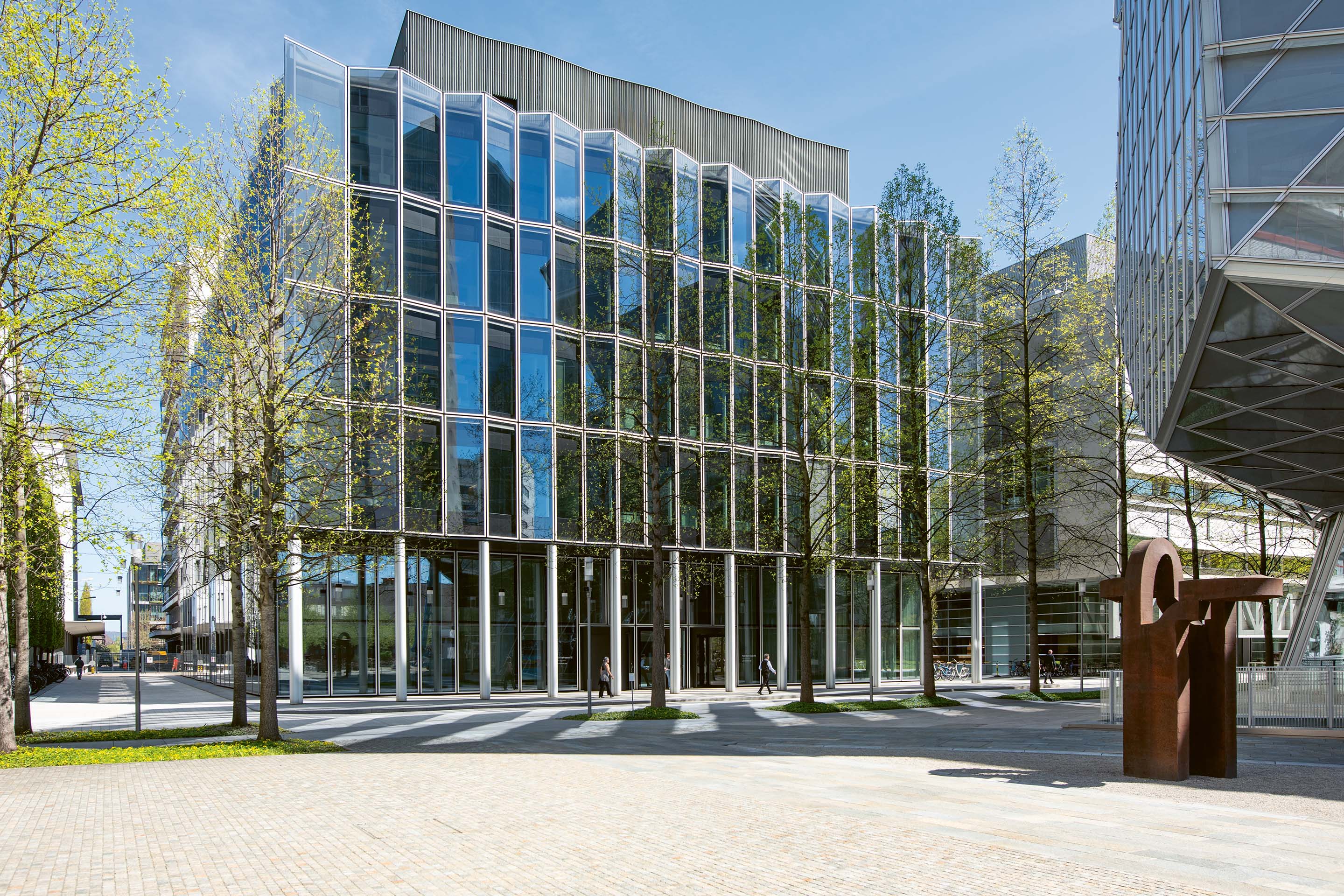 Das Laborgebäude (2008) auf dem Novartis Campus in Basel ist ein klar gegliederter Kubus mit gefalteter Glasfassade und steht der Gebäude­skulptur von Frank Gehry gegenüber.