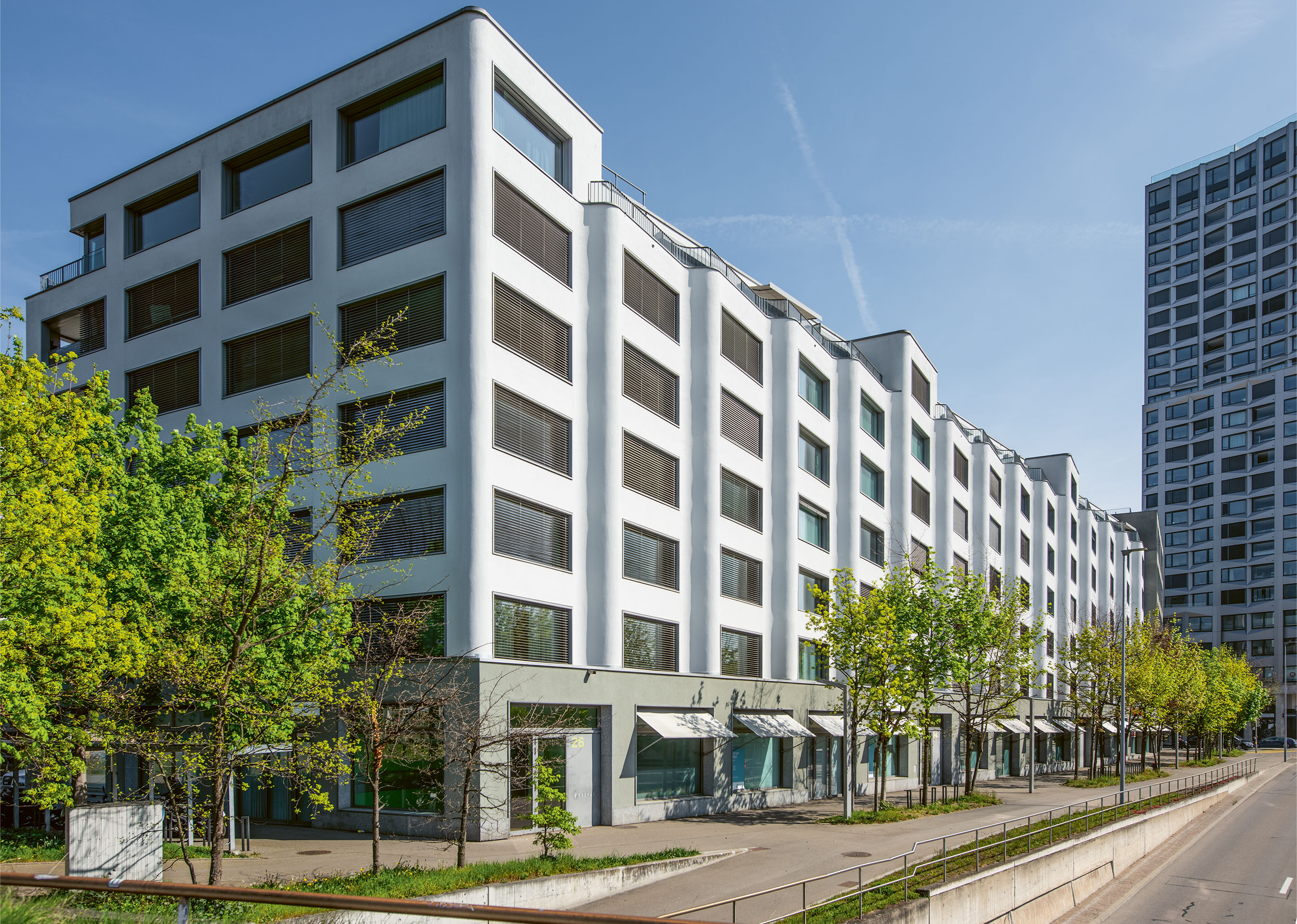 Die Wohnbebauung Limmatfeld (2011), Baufeld A, in Dietikon bildet den Auftakt zum Quartier Limmatfeld. Eine langgezogene, verputzte Wellenfassade säumt die befahrene Ueberlandstrasse.