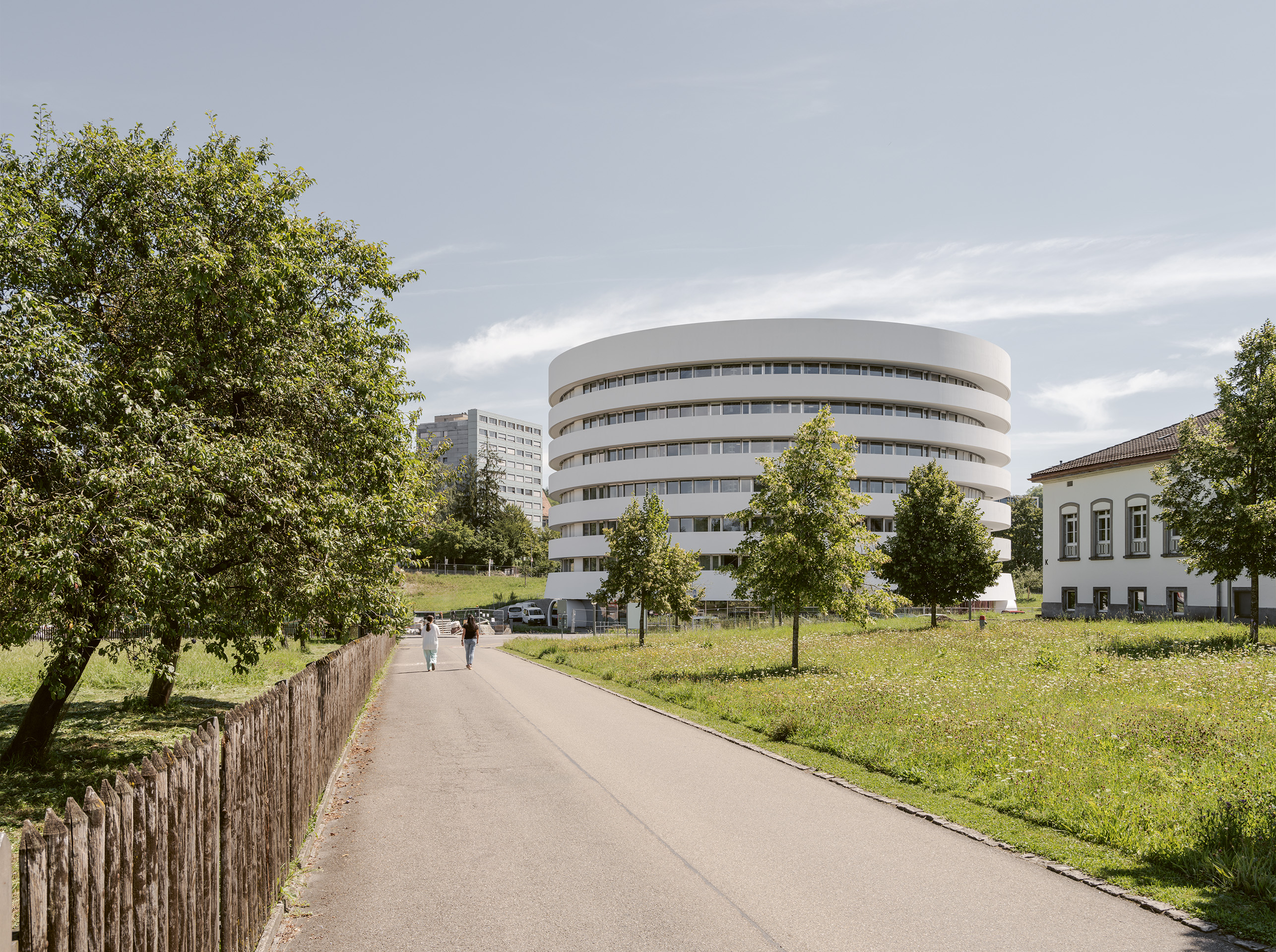 Der abstrakte weisse Zylinder des Laborgebäudes bildet im Stadtraum ein kontrastreiches Pendant zum hölzernen, gestaffelten Akutspital.