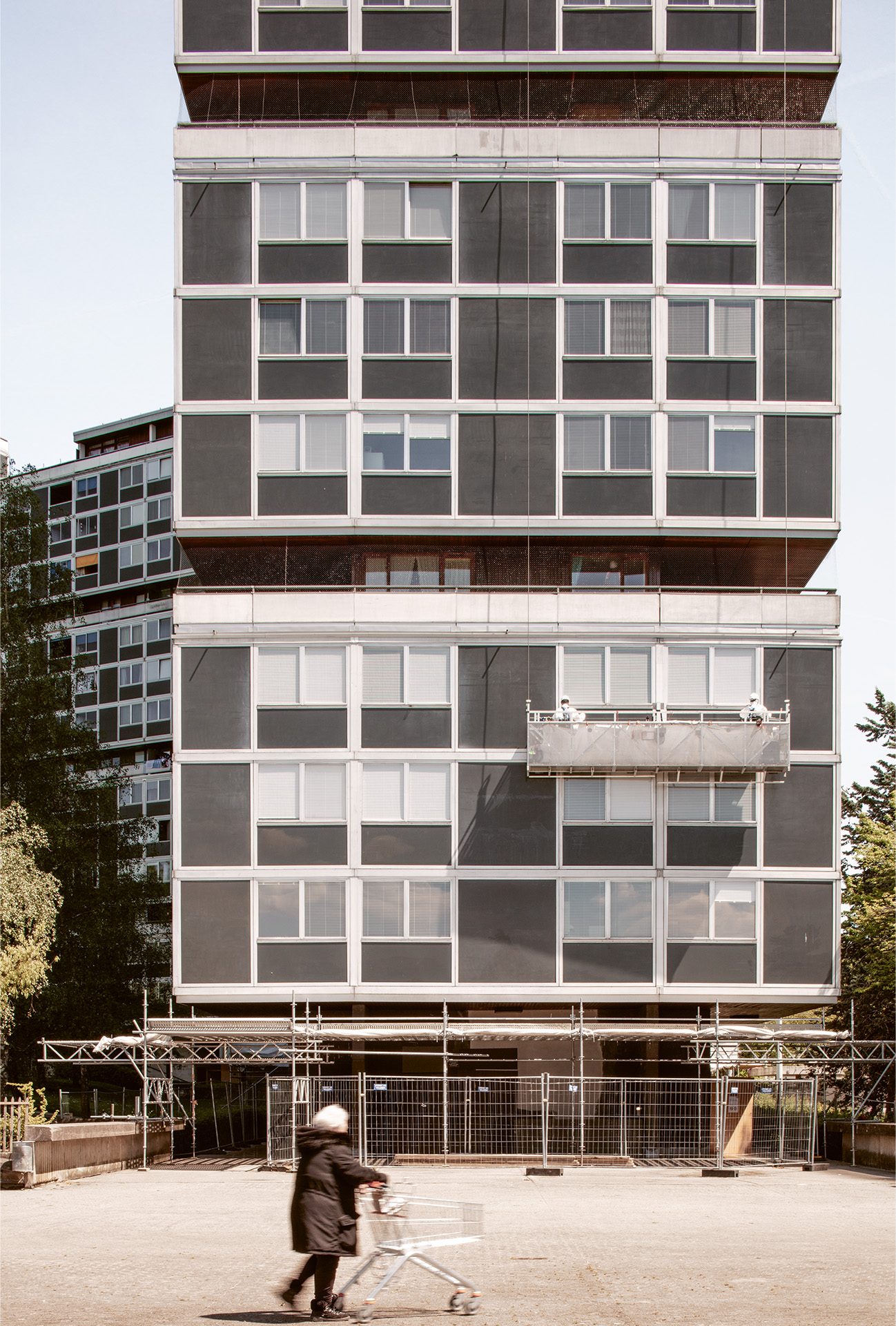 Façade de la Cité du Lignon à Meyrin lors de travaux de maintenance, avec nacelle et échafaudage.