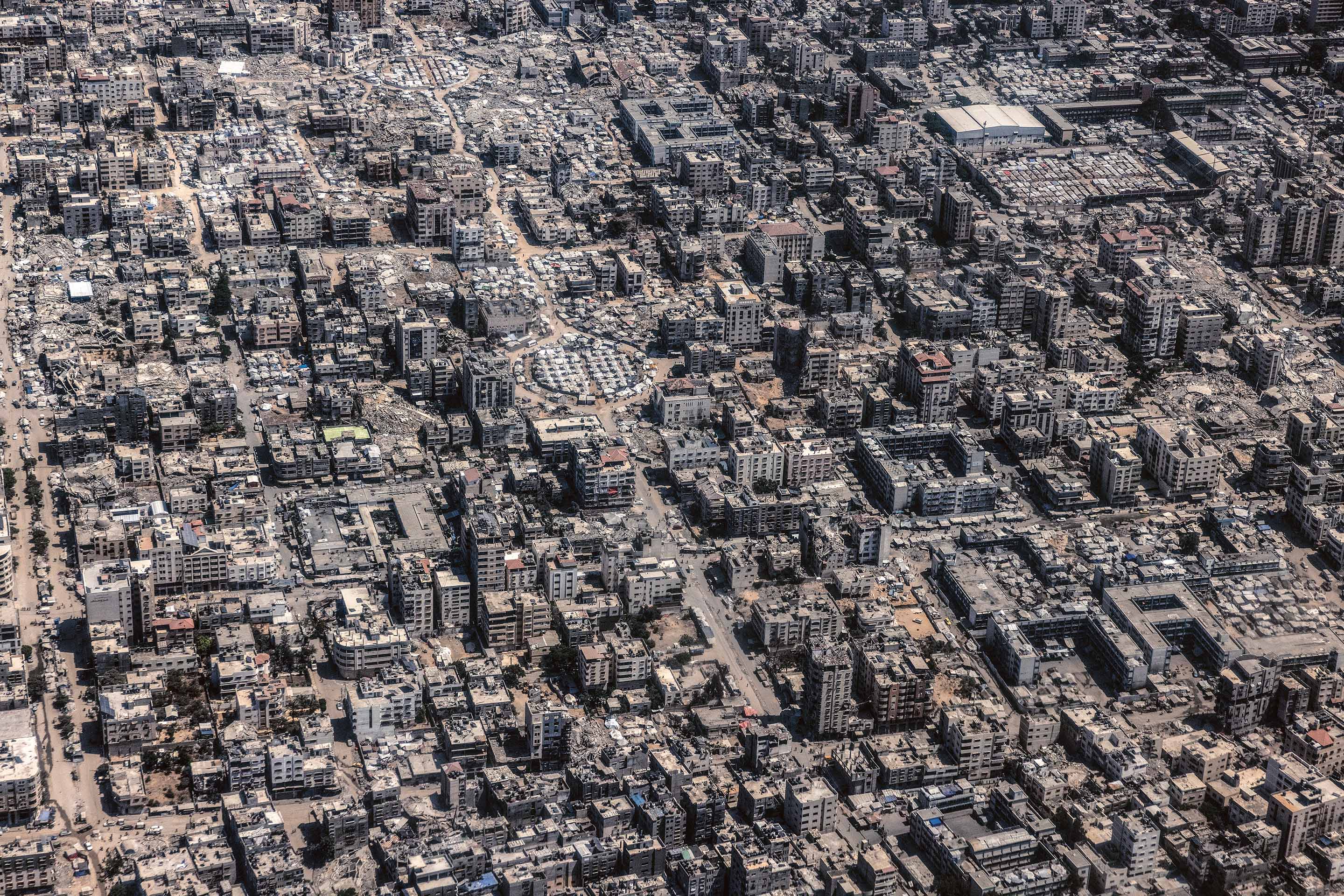 Tendopoli sovraffollate occupano rotatorie, cortili e spazi tra le macerie nella città di Gaza, agosto 2025.