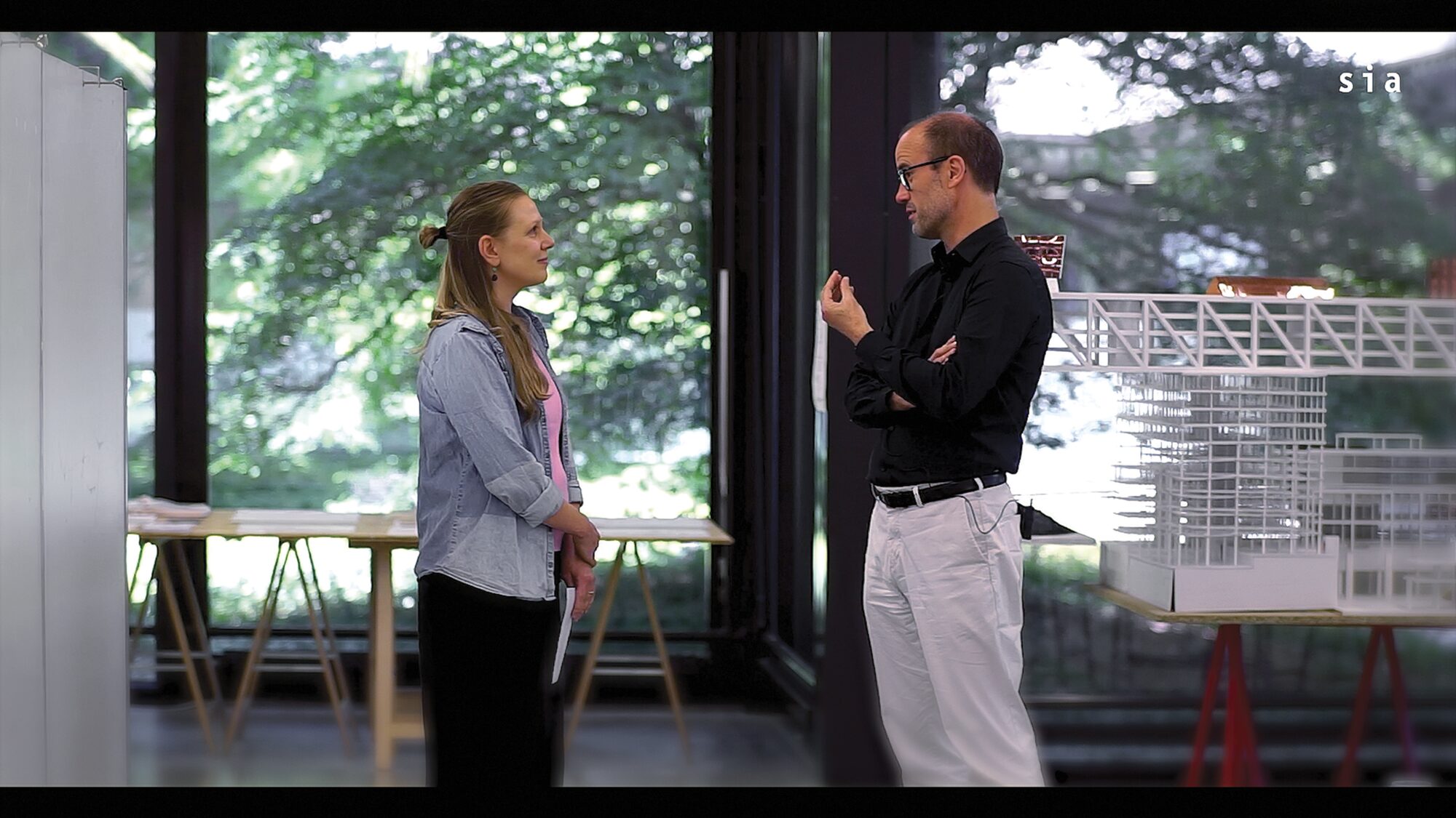 Tom Avermaete et Maria-Theresa Lampe en conversation devant des maquettes d’architecture, image extraite de la vidéo du Prix Master Architecture SIA.