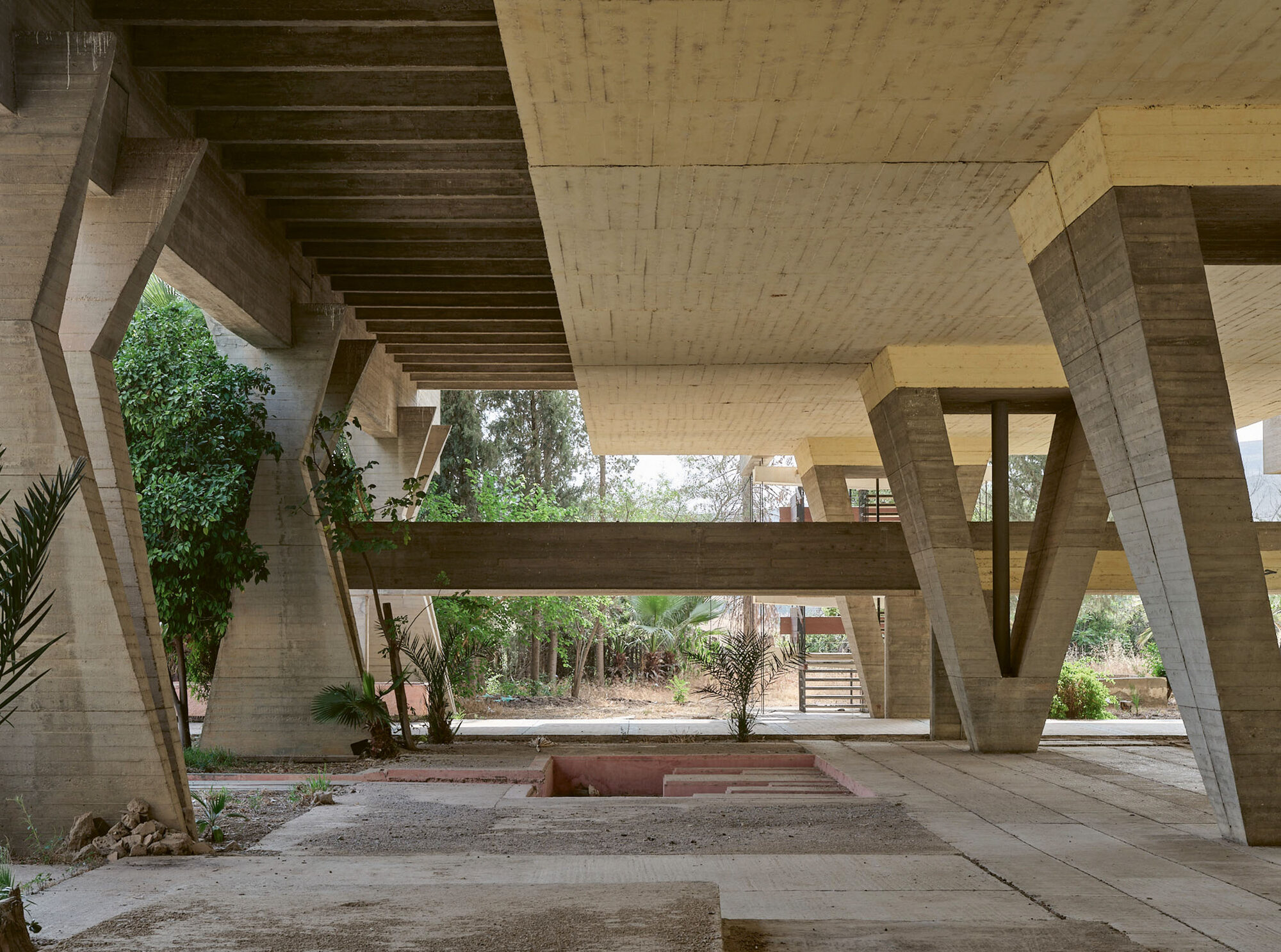Espace extérieur couvert sous l’hôtel, structure en béton sur pilotis en V, Sidi Harazem
