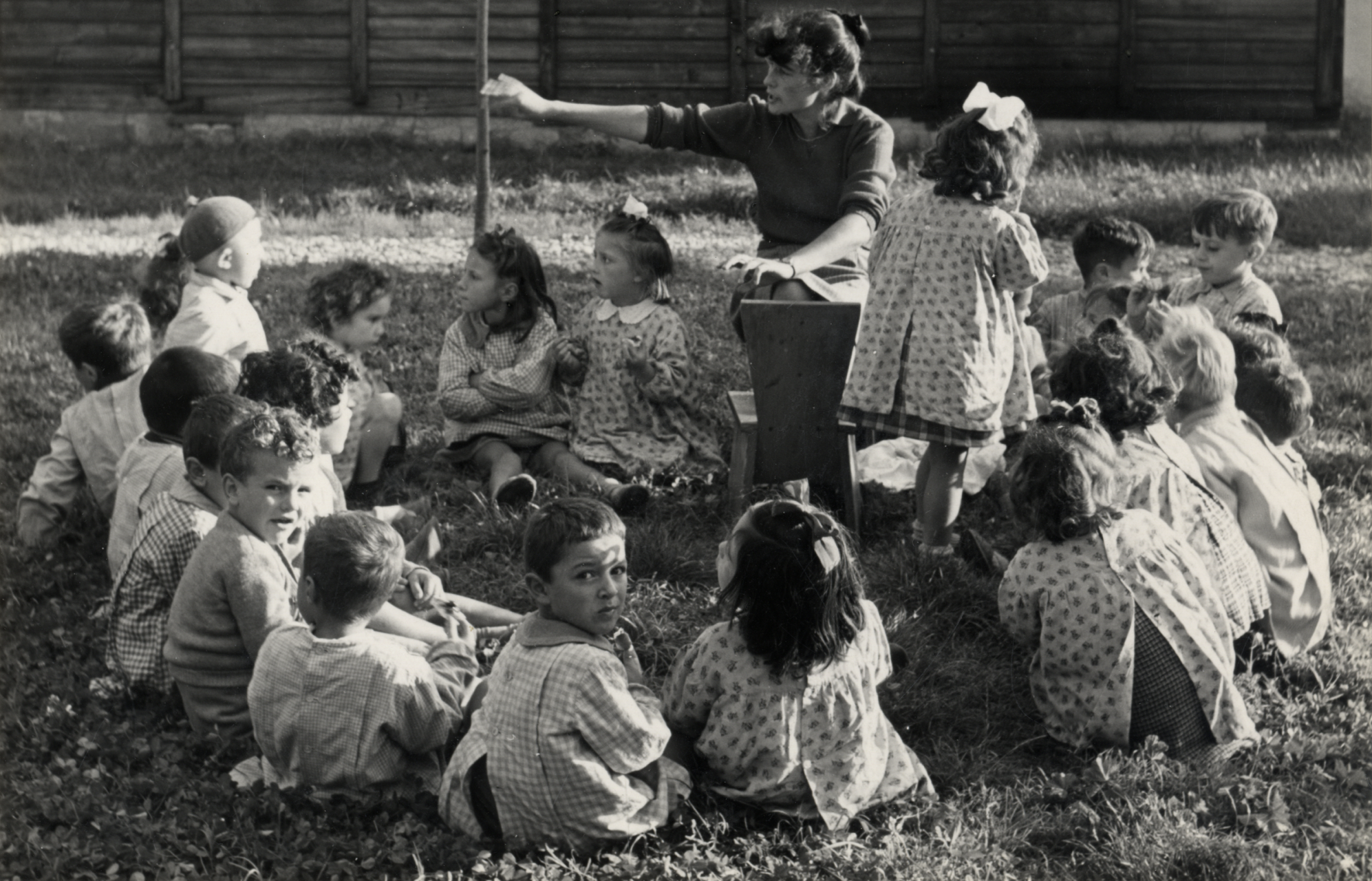 L’educatrice svizzera Rosellina Mandel, successivamente fotografa, compagna del fotografo Werner Bischof e direttrice di Magnum Photos Schweiz, con le bimbe e i bimbi del CEIS negli spazi aperti del villaggio.