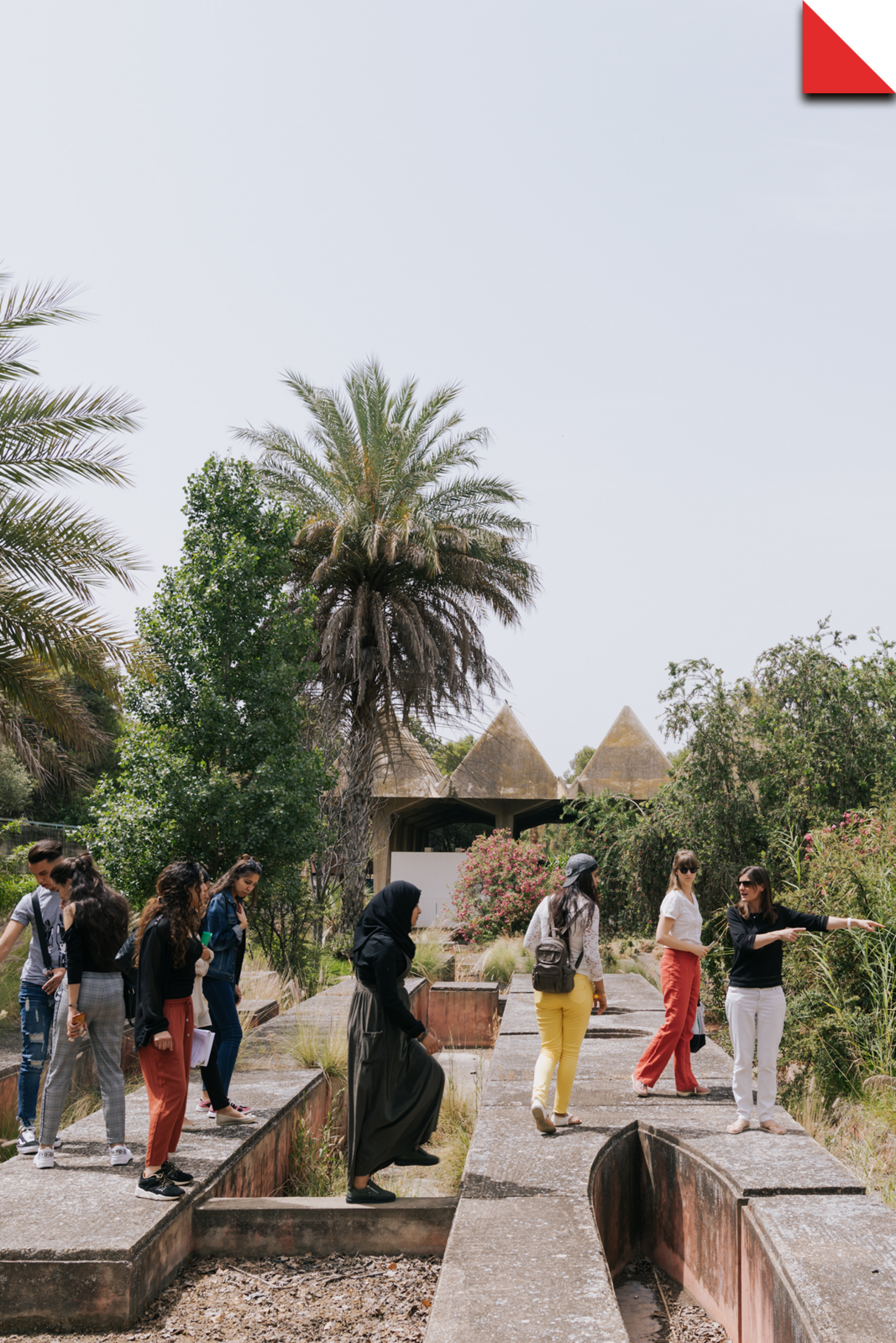 Groupe en visite guidée dans le ryad planté de palmiers de Sidi Harazem