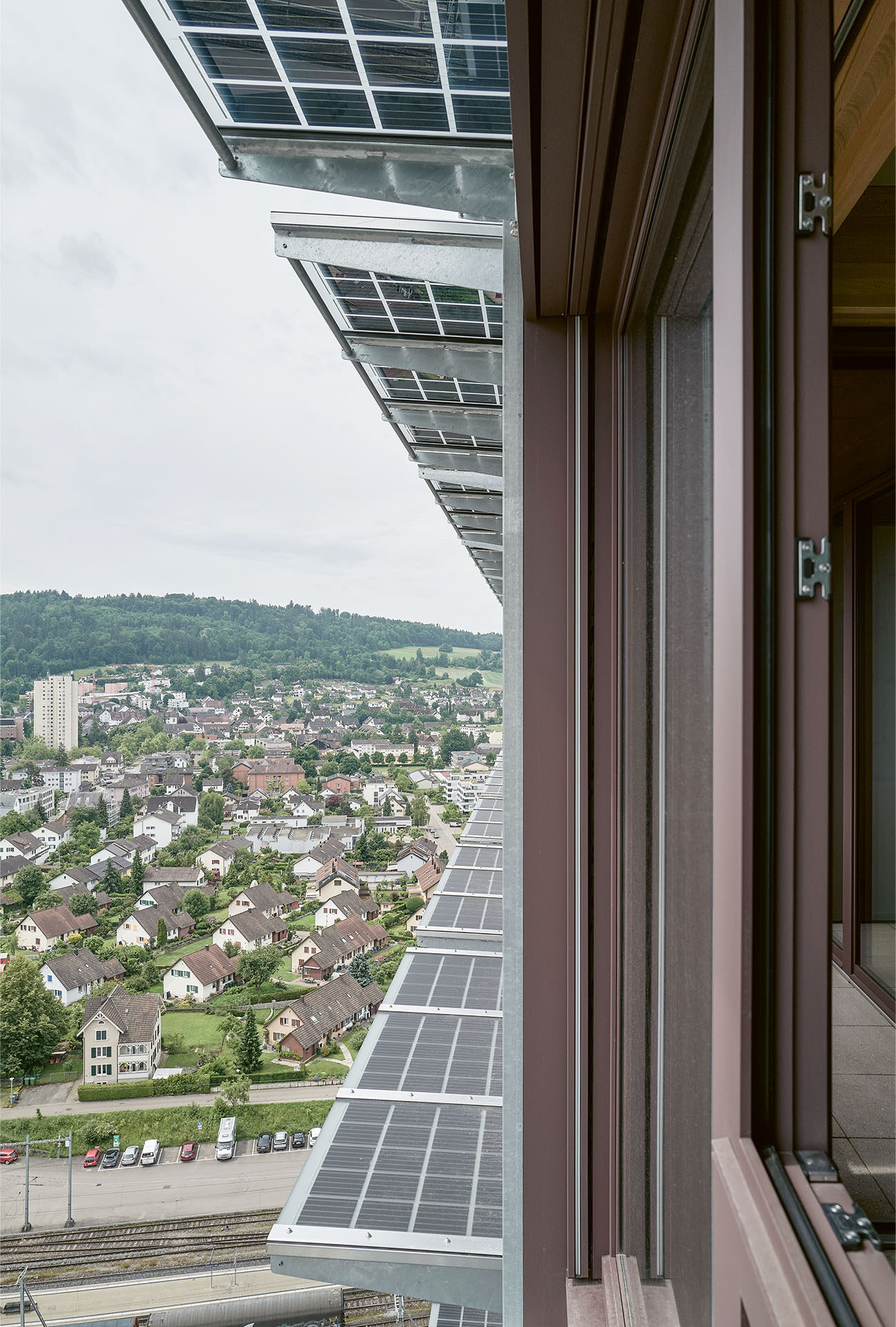 Vue depuis un appartement de la tour H1 à travers les panneaux photovoltaïques de façade, sur la vallée du Furttal.