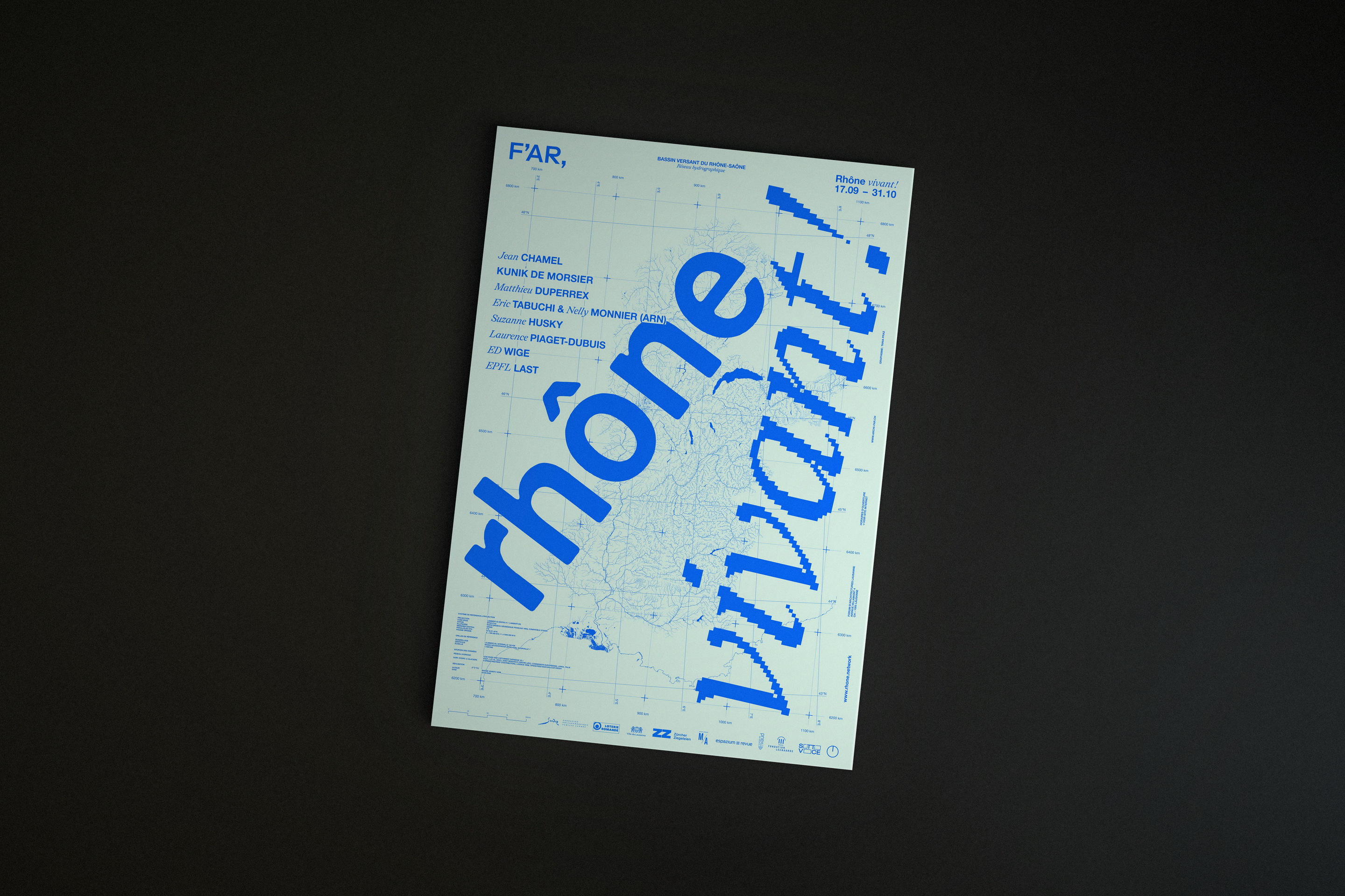 Affiche de l’exposition «Rhône Vivant!» photographiée sur le plateau sombre de la rédaction