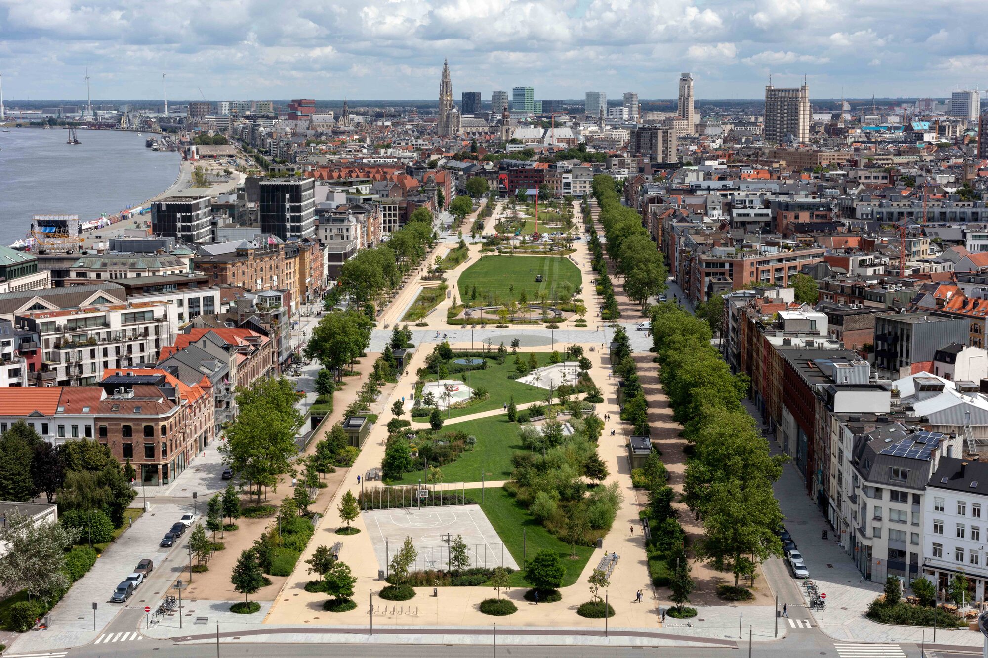 Vue aérienne du Zuidpark à Anvers: allées, prairies et alignements d’arbres entre les quartiers, avec l’Escaut à l’horizon.