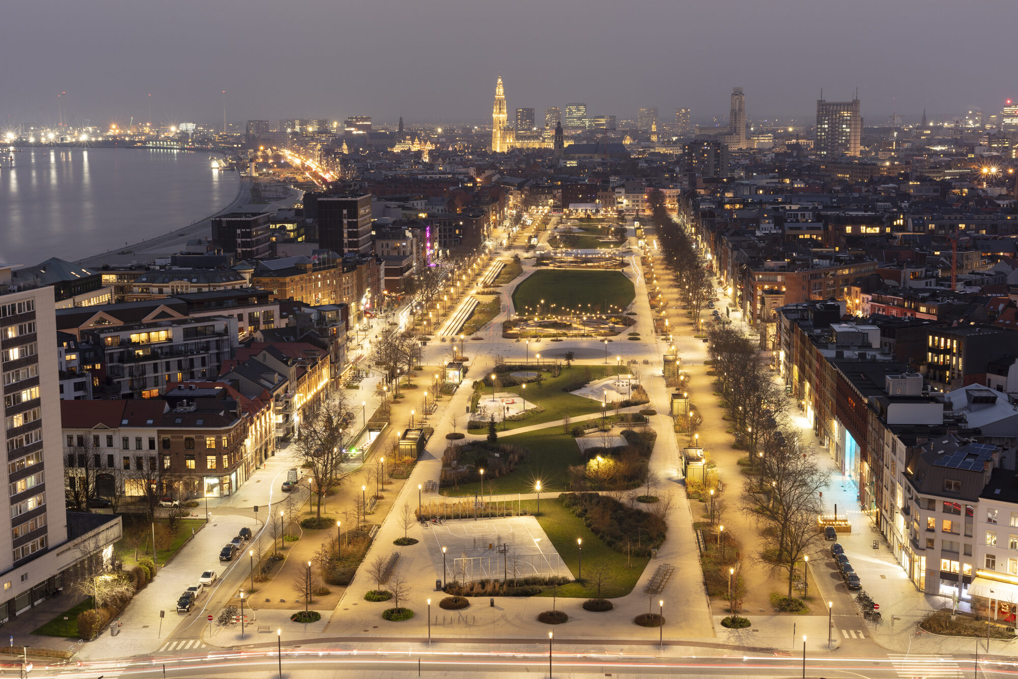 Vue aérienne nocturne du Zuidpark éclairé, avec la ville et l’Escaut en arrière-plan.