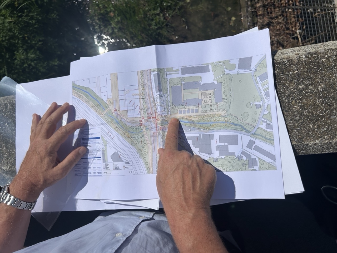 Doigt pointé sur le plan détaillé d’un tronçon de la Drize.