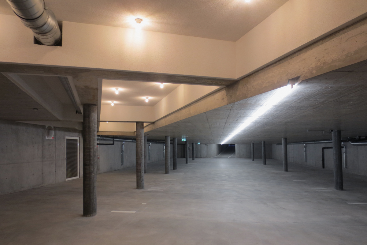 Die Tiefgarage wurde mit Lichtbändern und beleuchteten Kassettendecken sorgfältig gestaltet.