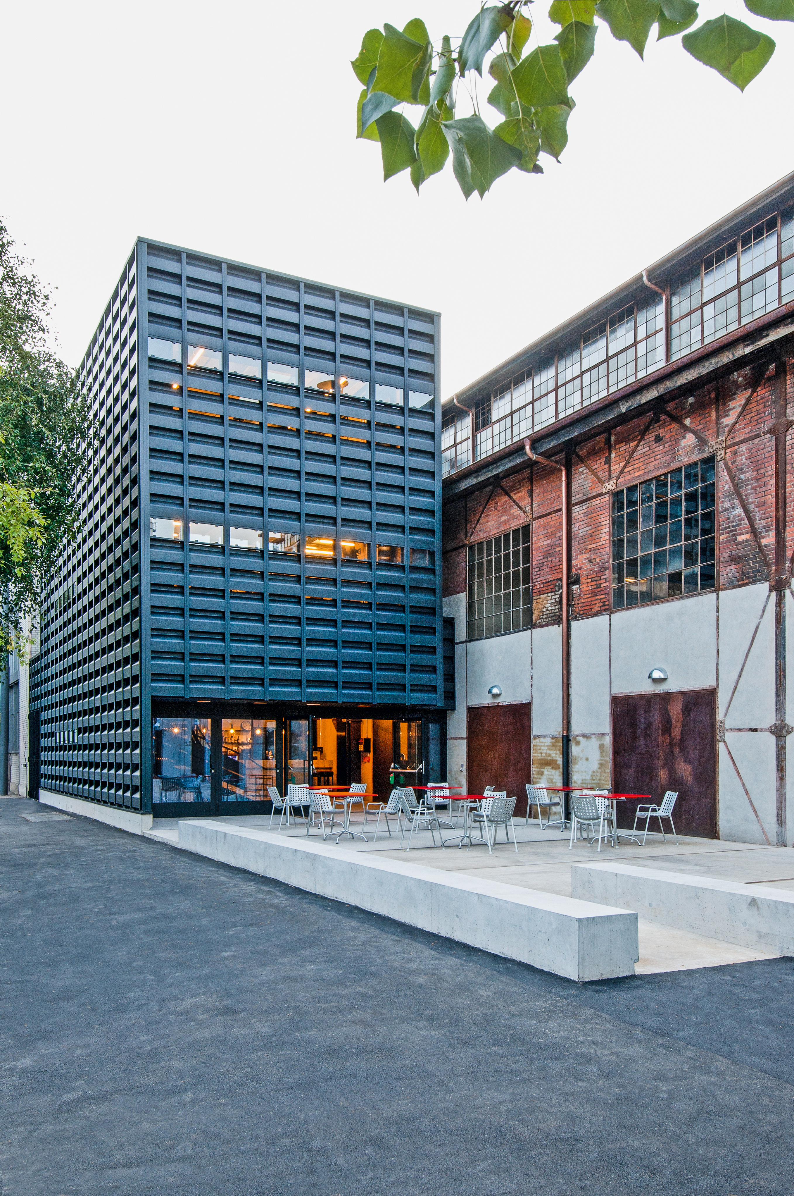 Der neue Vorplatz bildet den Auftakt zum Kulturlokal «Merkker». Die Fassade des Anbaus besteht aus Gussstahlelementen, die auf die frühere Nutzung als Schmiede verweisen.