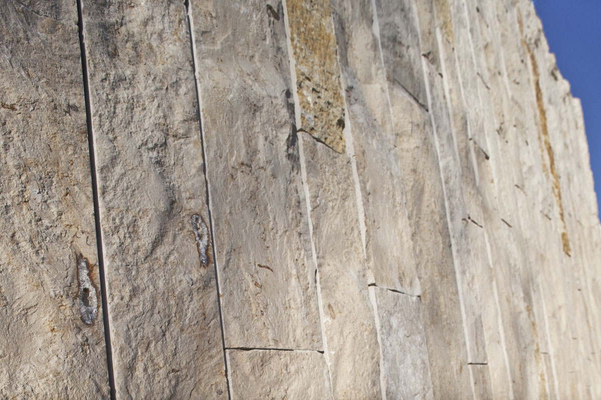 Beiger Kalkstein aus Süddeutschland verleiht den geschwungenen Betonmauern eine angenehme Wärme.