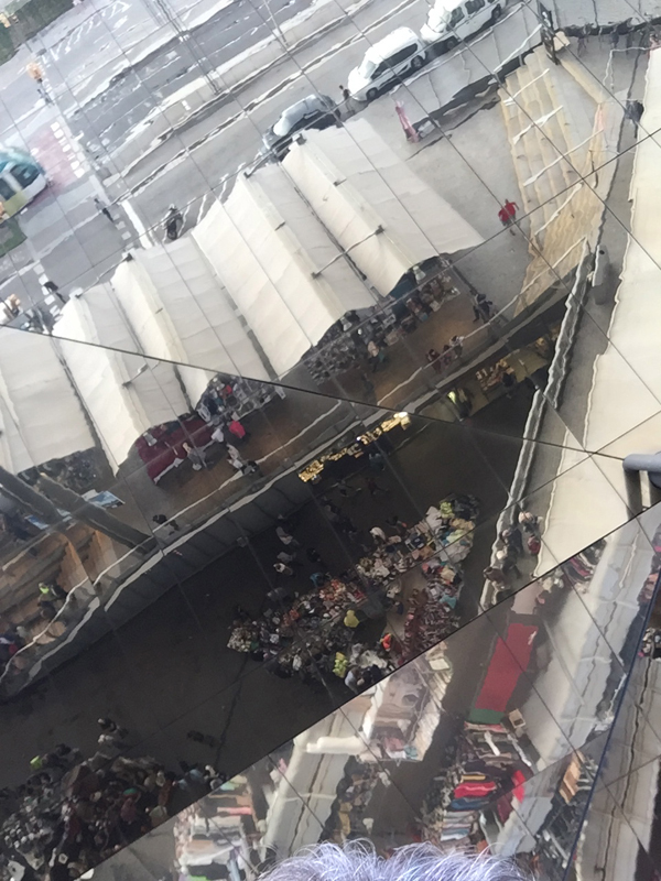 Unter dem verspiegelten Dach befinden sich Container und offene Verkaufsflächen.