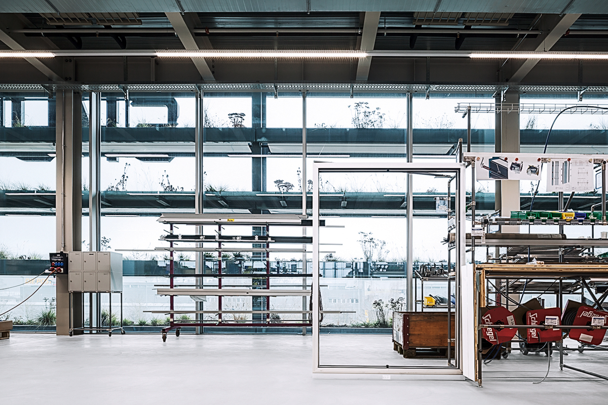 Ob vor den Büros oder vor der Montagehalle: Die vertikalen Gärten vor der Fassade des Sky-Frame-Hauptsitzes in Frauenfeld verbinden die beiden Funktionsteile zu einem Ganzen. Sie sind Ausdruck für die Untrennbarkeit der beiden Abteilungen.