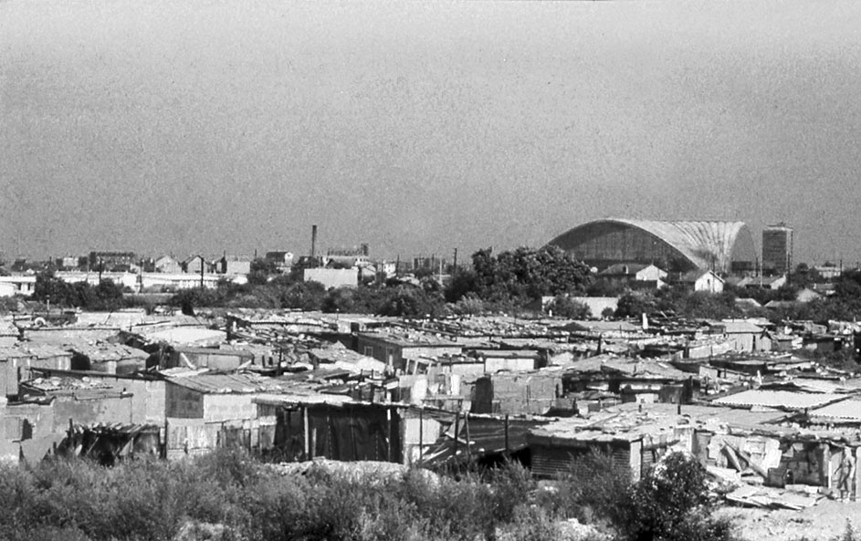 Bidonville nelle vicinanze del Rond Point de la Défense, sullo sfondo il palazzo del CNIT, fine anni Cinquanta.