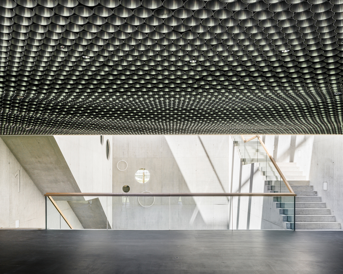 Die versetzt montierten Rohrabschnitte an der Decke bilden ein unregelmässiges Wellenmuster.