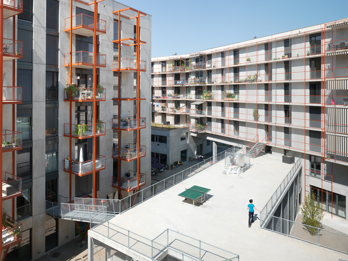 Les structures métalliques rouges des balcons et coursives sont destinées à être recouvertes de plantes