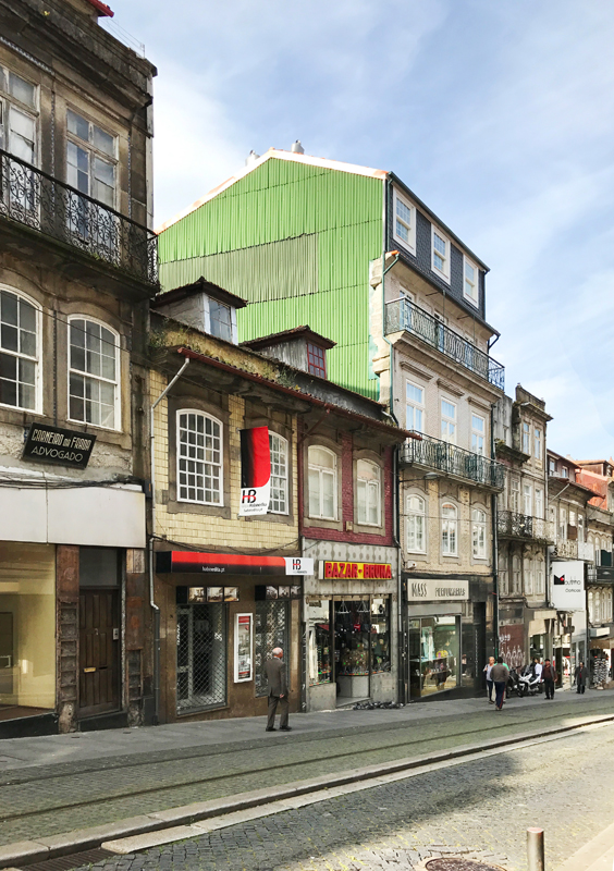 Brandmauern zwischen den Häuserzeilen sind immer wieder ein Blickfang: hier eine an der Rua Janeiro mit grün gestrichenem Wellblech über den Gleisen der Sightseeing-Tram Nr. 1.