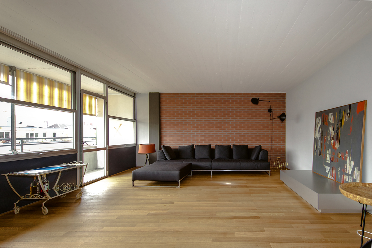 Eine sanierte Wohnung im 1. Obergeschoss, Wohnbereich. Die Sichtbacksteinflächen wurden in den originalen Zustand rückgeführt, die Holzböden saniert oder rekonstruiert. Durchgehende Balkone bilden die Fassade zum Hof.