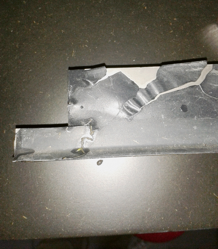 An einem Metallbauteil löst sich die Lackierung.