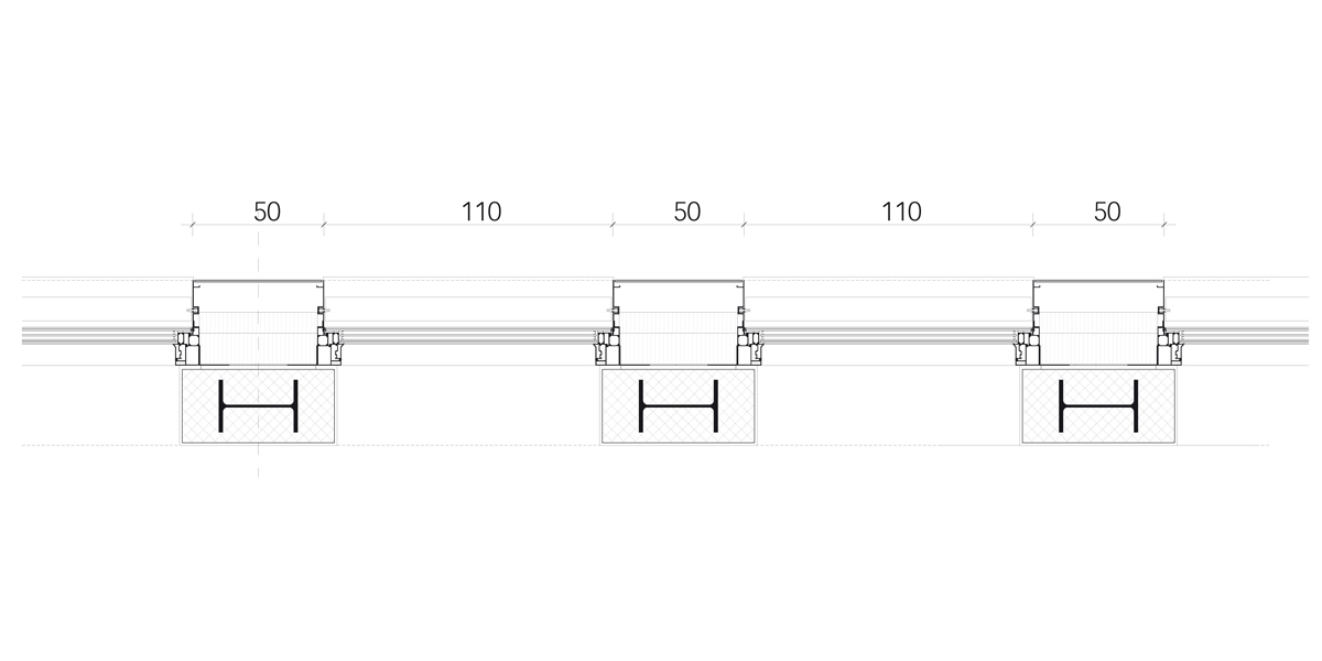 Alle Fassadenbauteile (Aluminium) – nach innen dampfdicht und nach aussen schlagregendicht – werden auf einer durch­laufenden Stahlwinkelkonstruktion unten abgestellt und seitlich gehalten. Oben sind sie mit örtlichen Einschieblingen (dilatierend) in der Rohbaukonstruktion fixiert. Der Sonnenschutz ist aussenliegend montiert. Mit Brandschürzen von 90 cm konnte auf Sprinkleranlagen im Innern verzichtet werden.