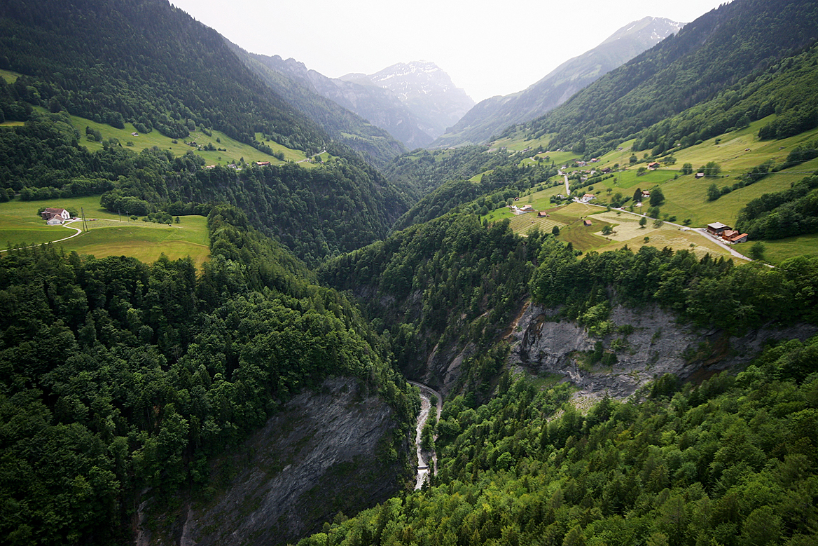 Luftbild des unteren Taminatals mit Standort des projektierten Brückenschlags zwischen Pfäfers (links, nicht im Bild) und Valens (rechts). Blickrichtung von Nord nach Süd, im Hintergrund in Bildmitte der Haldensteiner Calanda (2805 m ü. M.)