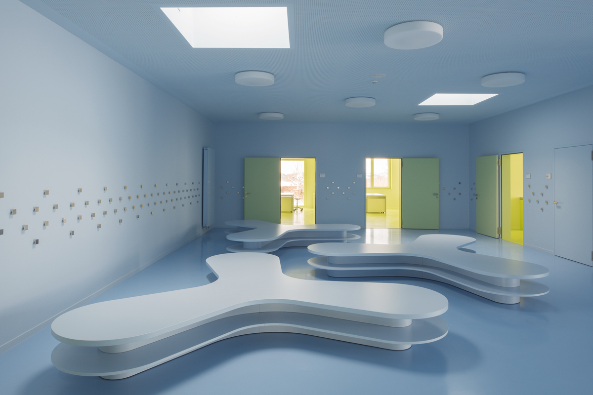 Garderobe in einer der zentralen Hallen des Obergeschosses. Alle Oberflächen – die mit Kunstharz belegten Möbel, der Polyurethanboden, der Gips an Wänden und Decken sowie die Heizkörper – bilden einen monochromen Hintergrund in Hellblau, was dem Raum eine wohltuende Ruhe verleiht (Wand und Decke: NCS S 1020-R90B; Boden: NCS S 1040-R90B).