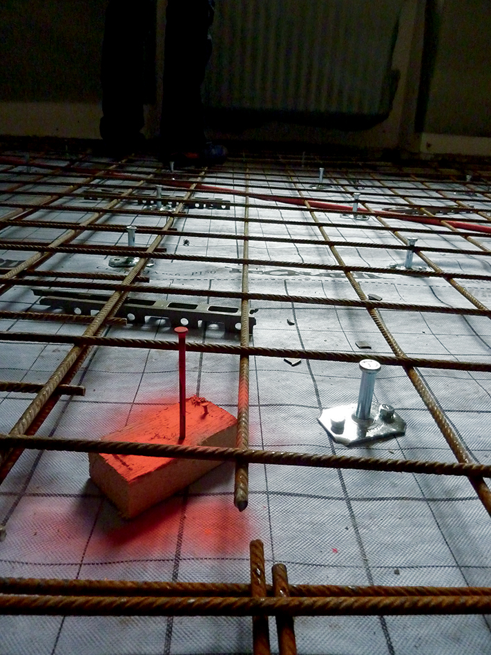 Intervento di risanamento. Connettori metallici fissati sul telo impermeabile traspirante, rete elettrosaldata. In colore rosso-arancione il chiodo che segna la quota superiore del getto.