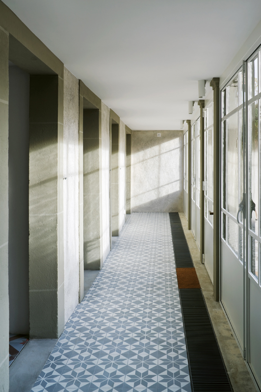 Dem Gartengeschoss ist nicht anzusehen, dass es hinzugefügt wurde. Durch die vorgelagerten Eisentore erhält es den Charakter einer Orangerie. Hier liegt der neue Hauseingang.