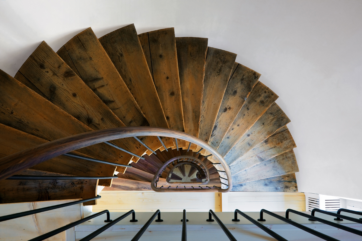 Die Bestandstreppe setzt sich mit einer zugefügten Wendelung hinunter ins neue Gartengeschoss fort. Die Verlängerung interpretiert die Materialien des Bestands, die hier zu einem neuen gestalterischen Ausdruck finden.