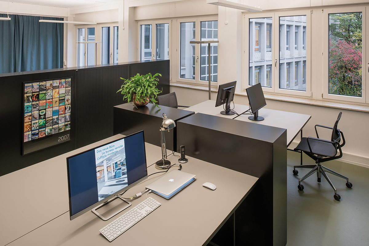 Die Arbeitsplätze sind visuell und akustisch  vonein­ander abgeschirmt. Gleichzeitig lassen sich die Kuben auch als Stehpult gebrauchen. Ablageflächen und Rückseiten der Regale bieten Gelegenheit für kontrolliert indivi­duellen Ausdruck.