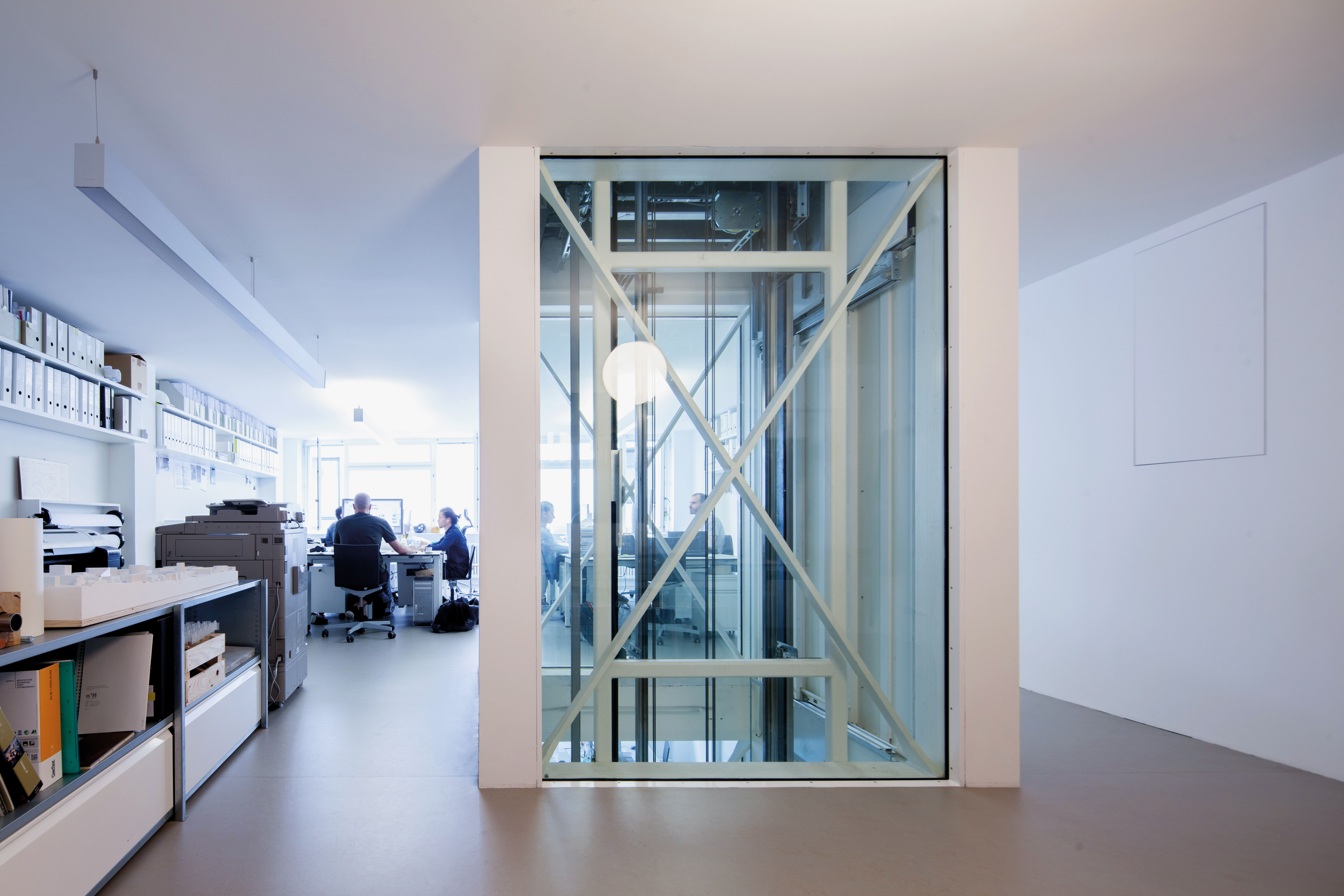 La cage vitrée de l’ascenseur s’insère jusqu’au fond des espaces de travail.