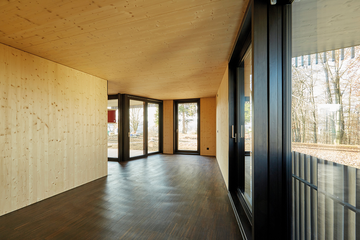 Im Innern sind Decke, Innenausbauten und Wände aus Fichte. Die Wohnungsgrundrisse sind fliessend um einen Kern herum gestaltet.