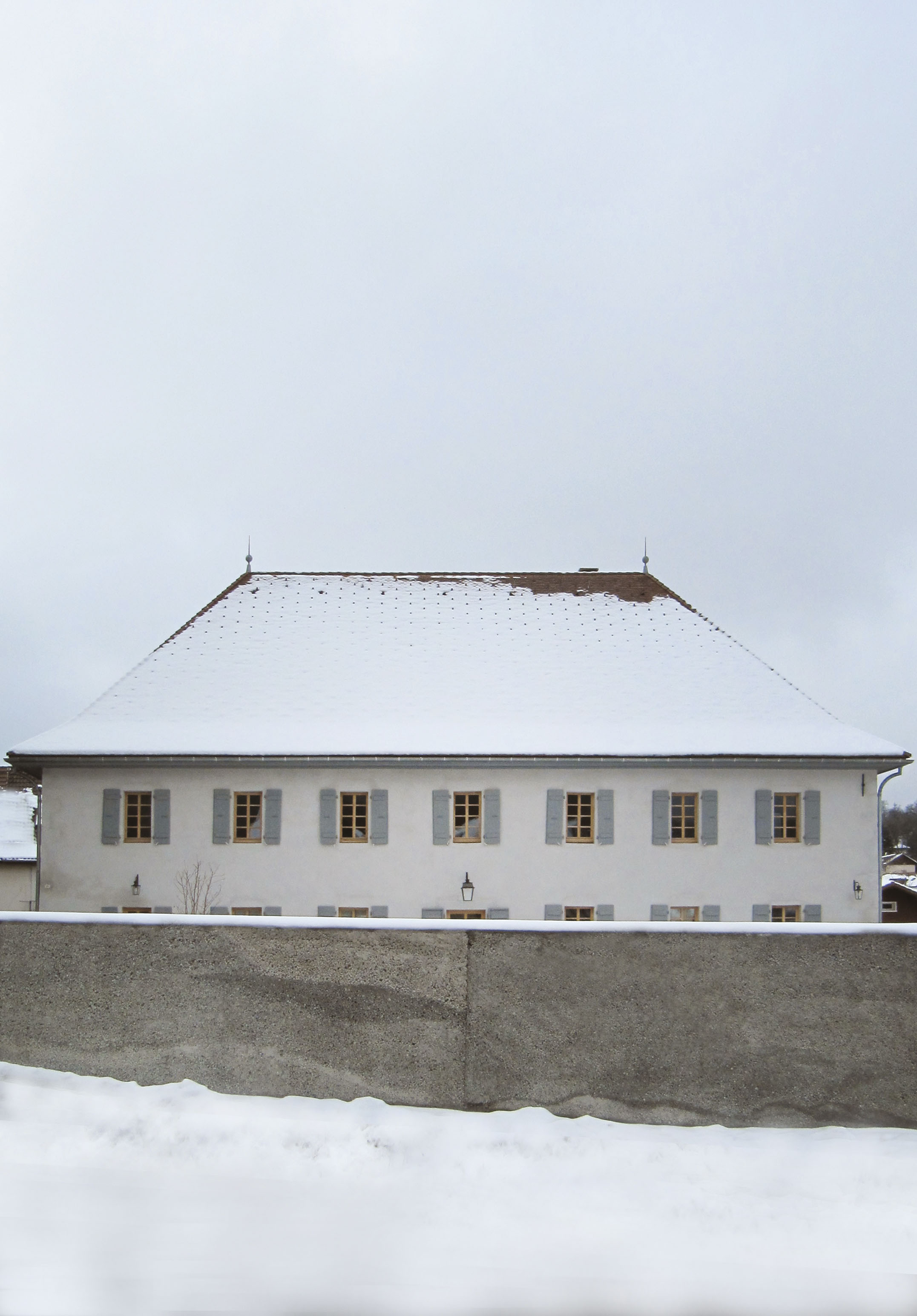 Le presbytère rénové, derrière le mur en béton « caverneux » qui clôt le jardin public
