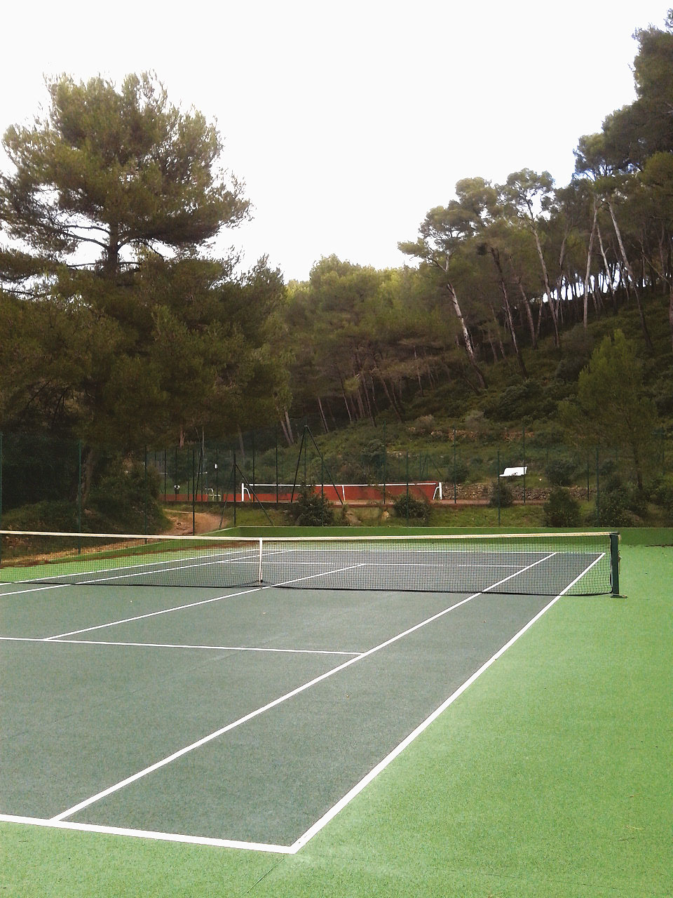 Les trois terrains de tennis bien calés dans la courbe et la pente du vallon, autrefois cultivé et aujourd’hui recolonisé par les pins.