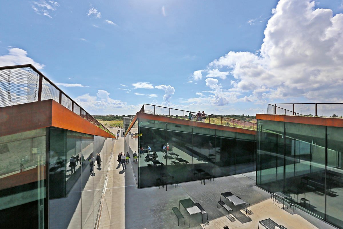 Wer den Innenhof des Museumsneubaus betritt, nimmt den Aussenraum als auf- und absteigende Dachlandschaft wahr, als eine dramatische Inszenierung, die sich in den tageshellen Innenräumen fortsetzt.