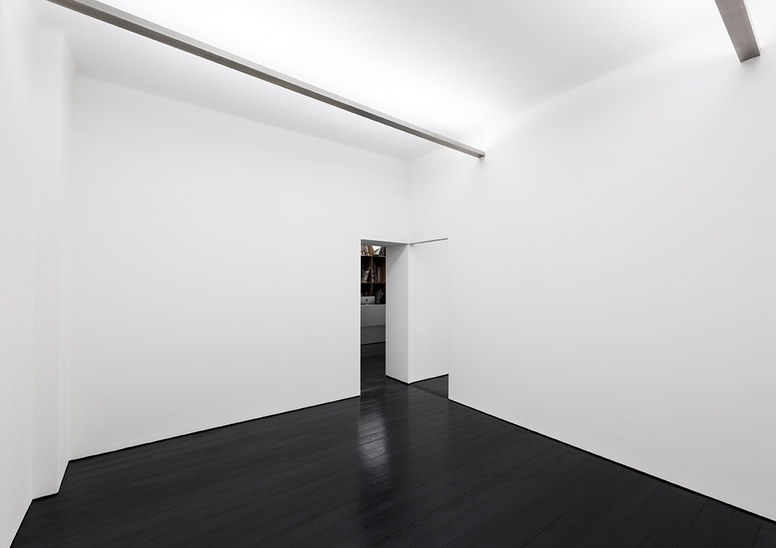 Die in die Raumecken verlagerten Durchgänge lassen zusammenhängende Flächen zum Hängen der Bilder entstehen.