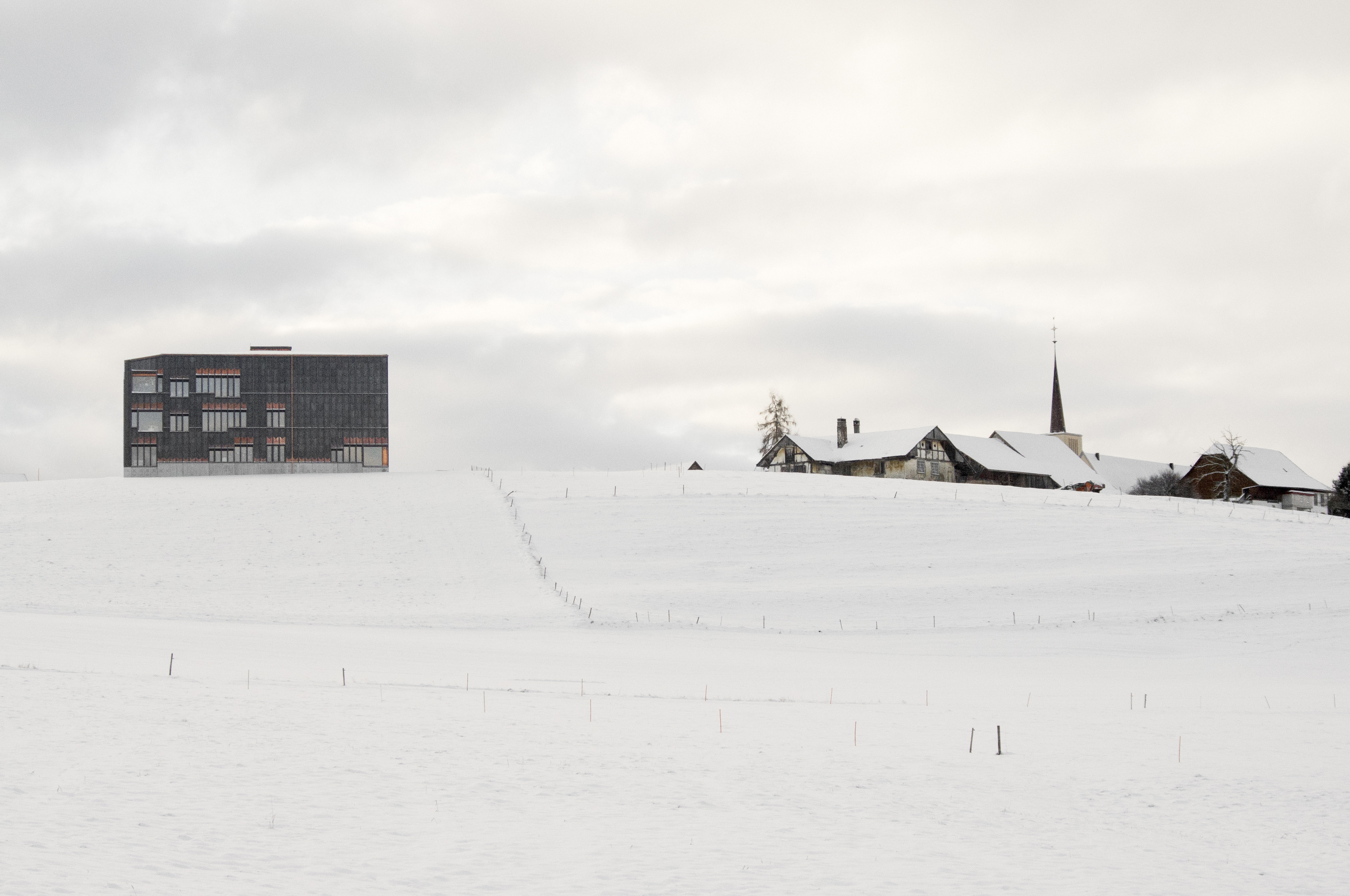 Vue de la façade nord. À droite, le village d'Orsonnens et l'église Saint-Pierre-et-Paul oeuvre de Fernand Dumas (1892-1956).