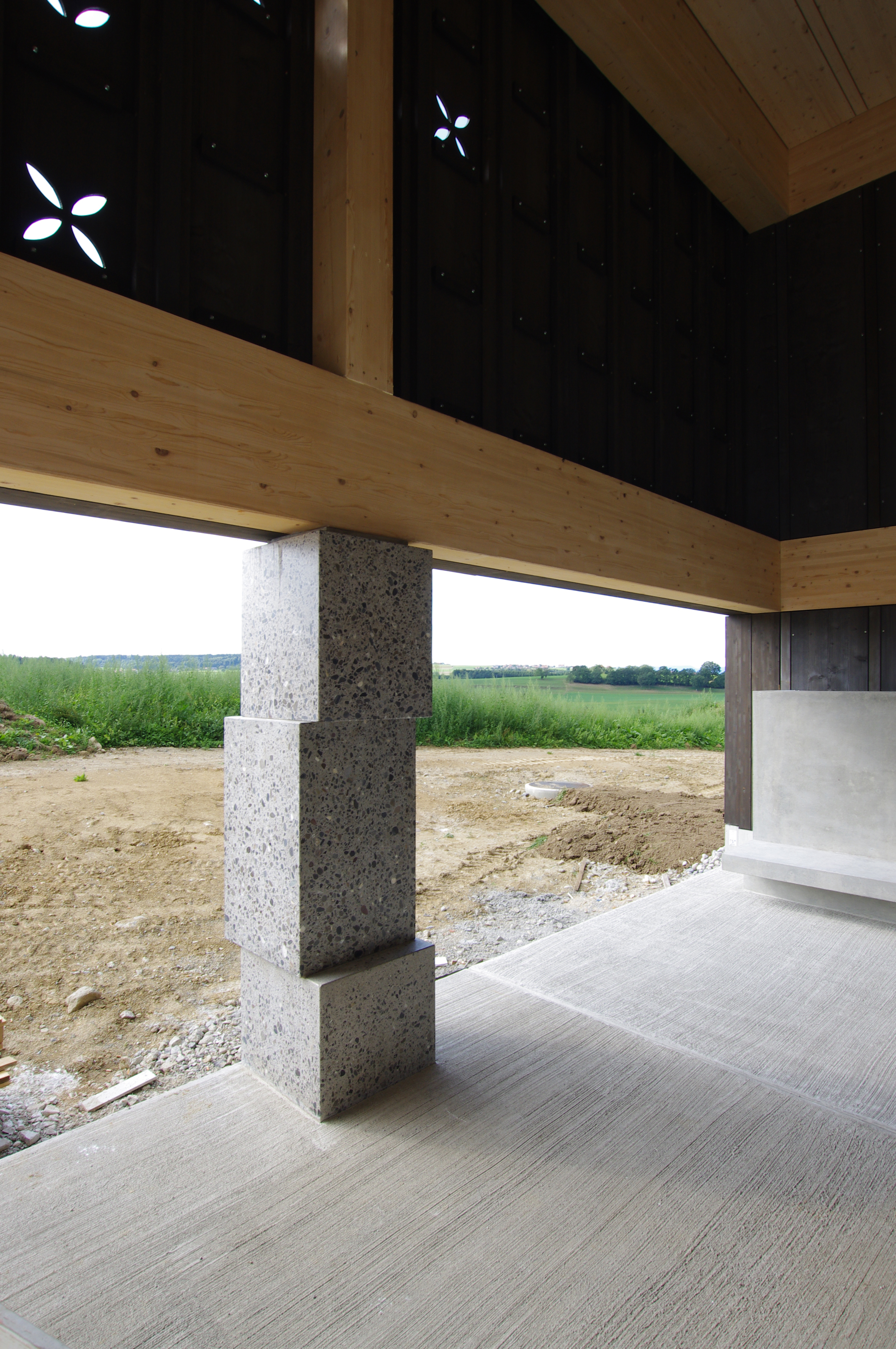 Vue d'une colonne en béton depuis le préau couvert